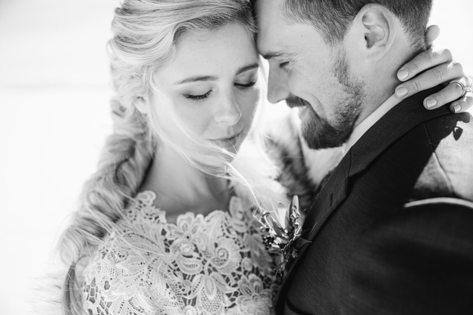 black and white photo of bride and groom with their foreheads together and looking down