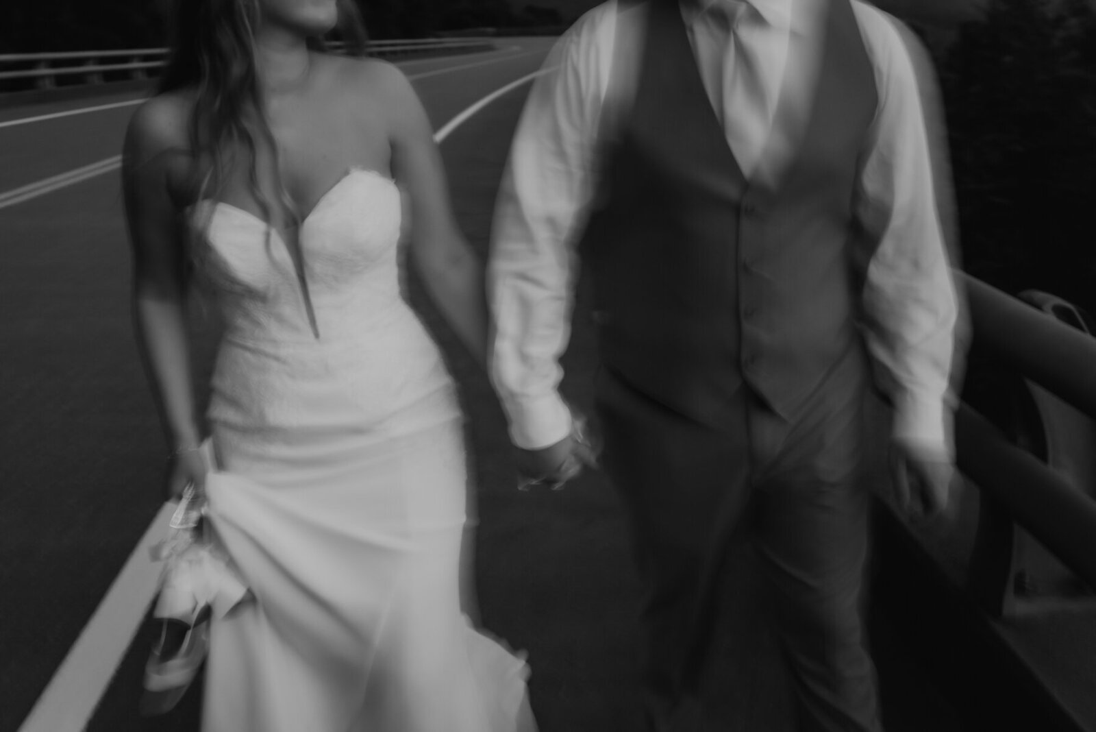 black and white candid wedding photo of bride and groom holdin ghands and running together photographed by gatlinburg photographers
