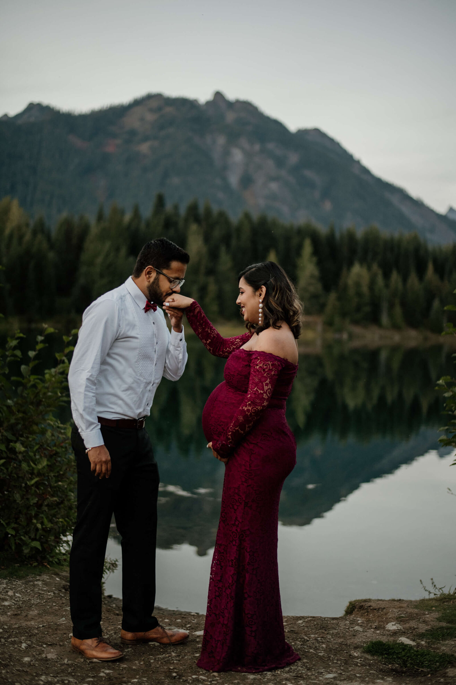 Husband kisses pregnant wife's hand.
