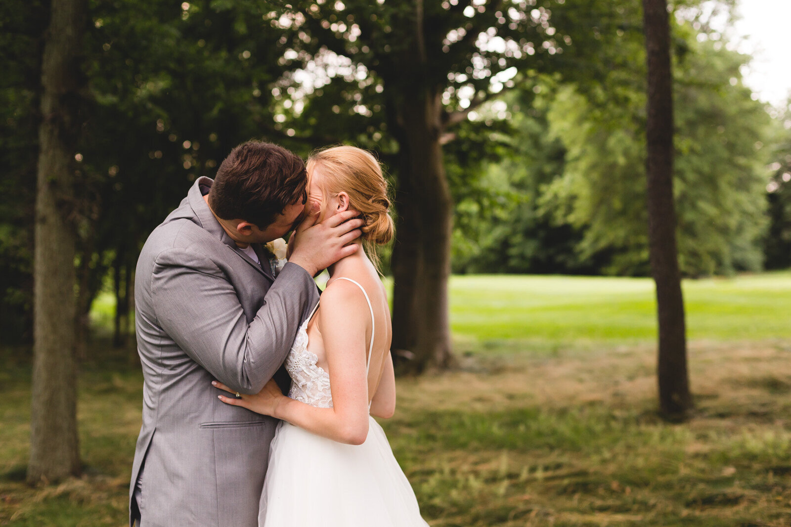 bride and groom kiss during candid portraits on golf course ohio