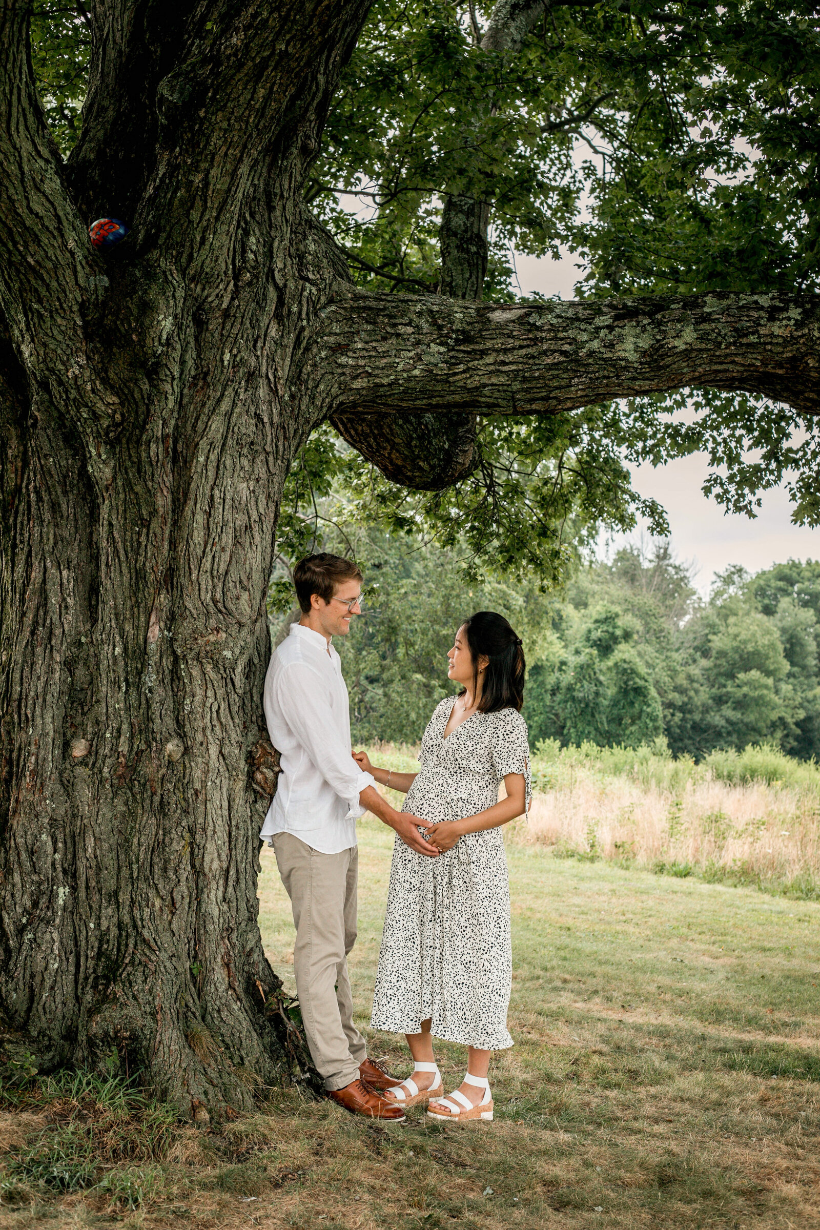 couple looking at each other under a tree