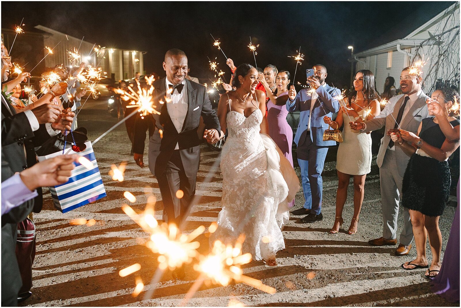 Bride and groom walking through people holding sparklers