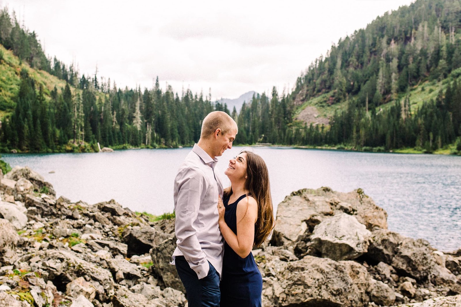 Couple looking at each other and smiling at PNW mountainside