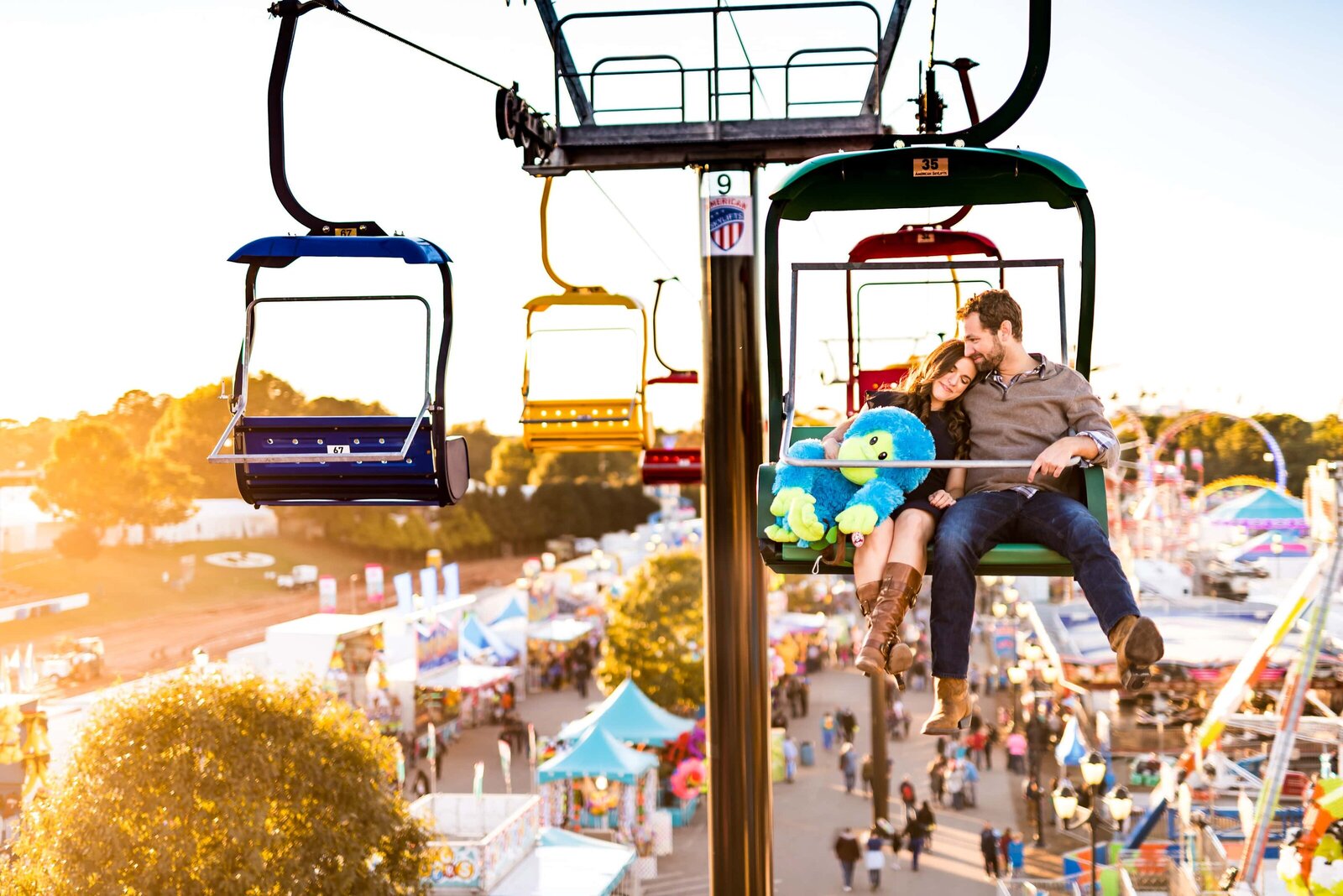 couple rides on chair lift at North Carolina State Fair engagement photos
