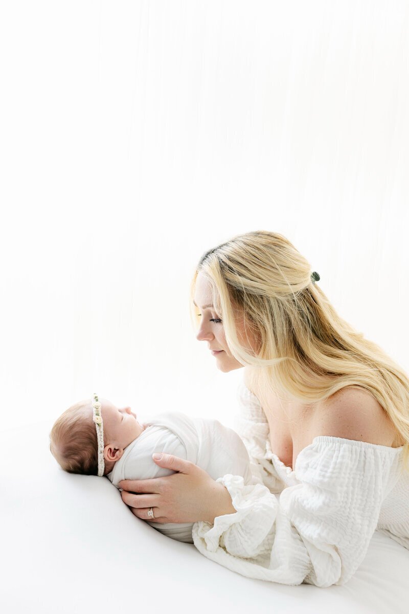 mom looking at newborn baby sleeping taken by new jersey newborn photographer
