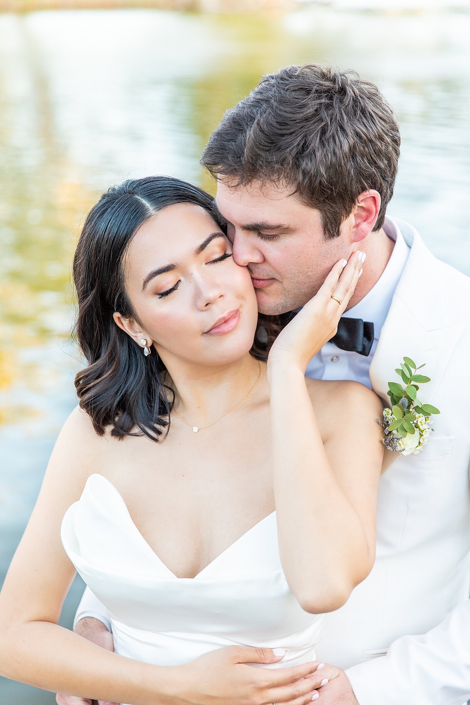 Groom kissing bride at Malibu Lake.