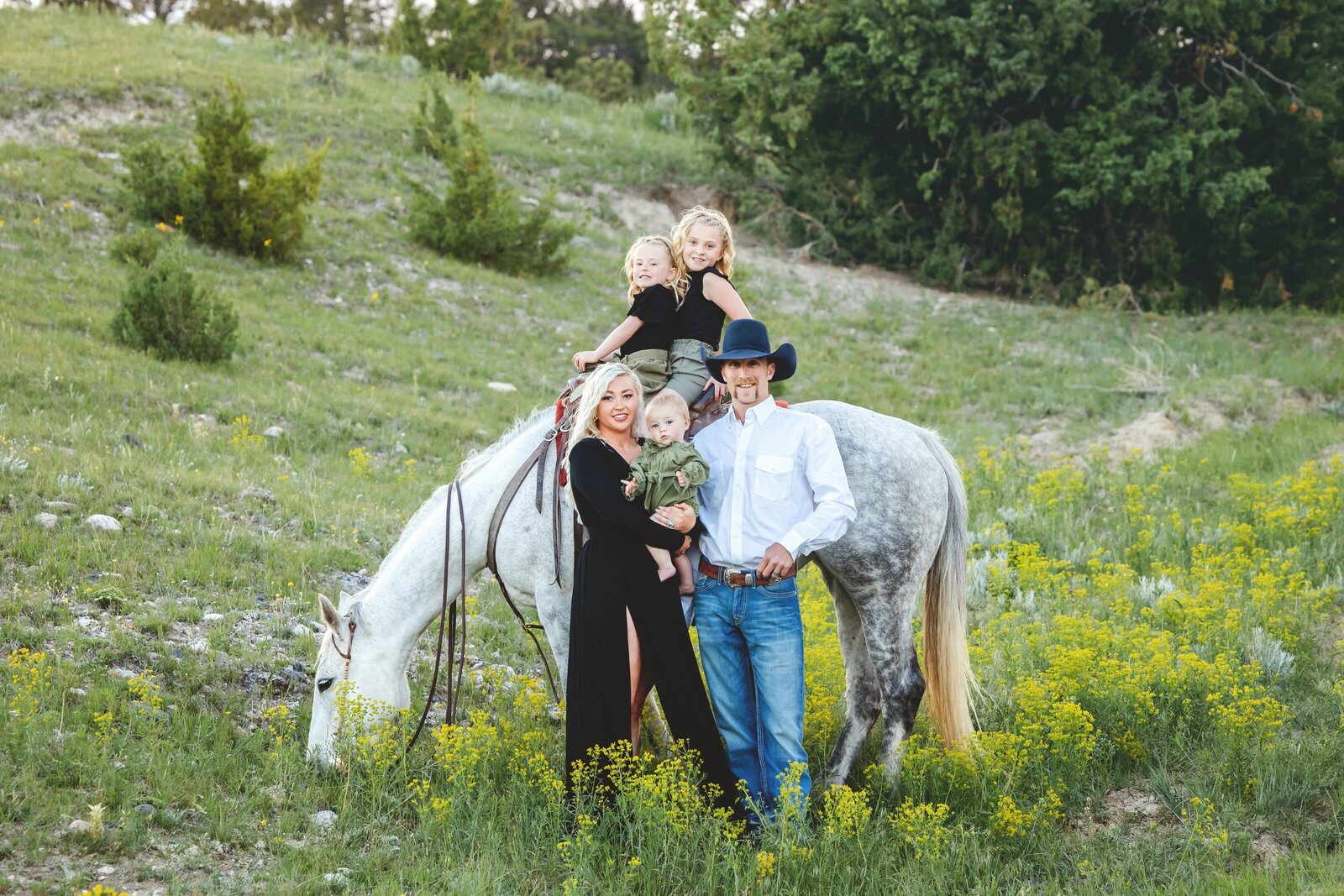 Family with their horse in a field of yellow flowers in SE Wyoming