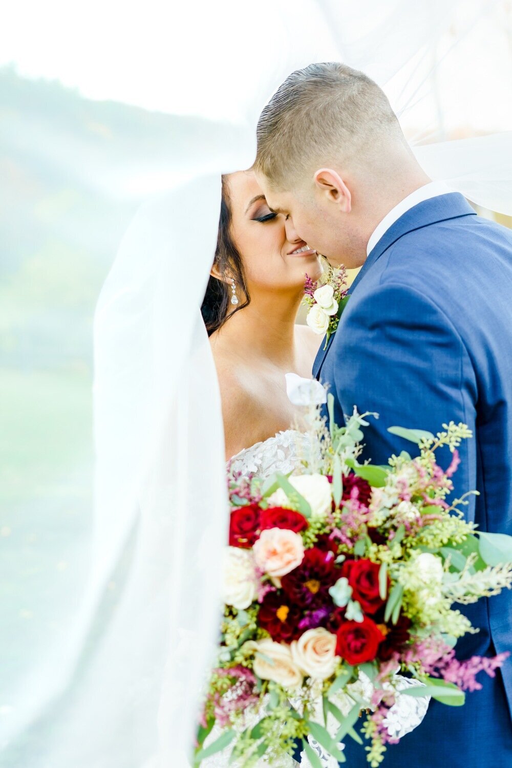 Bride and groom kissing with colorful bouquet