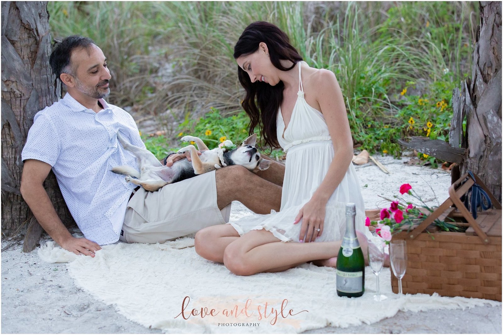 Engagement Photography on Anna Maria Island. Couple with their dog on a blanket having a picnic