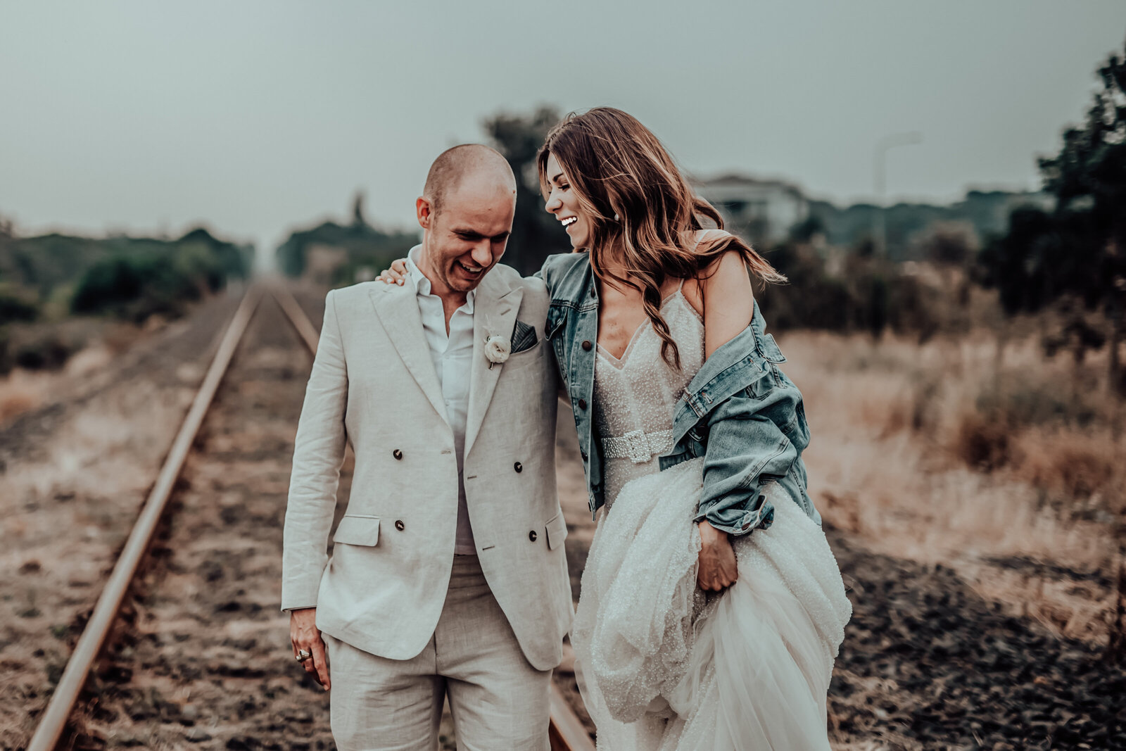 Newlywed couple's railway track pose with a soft-focus backdrop