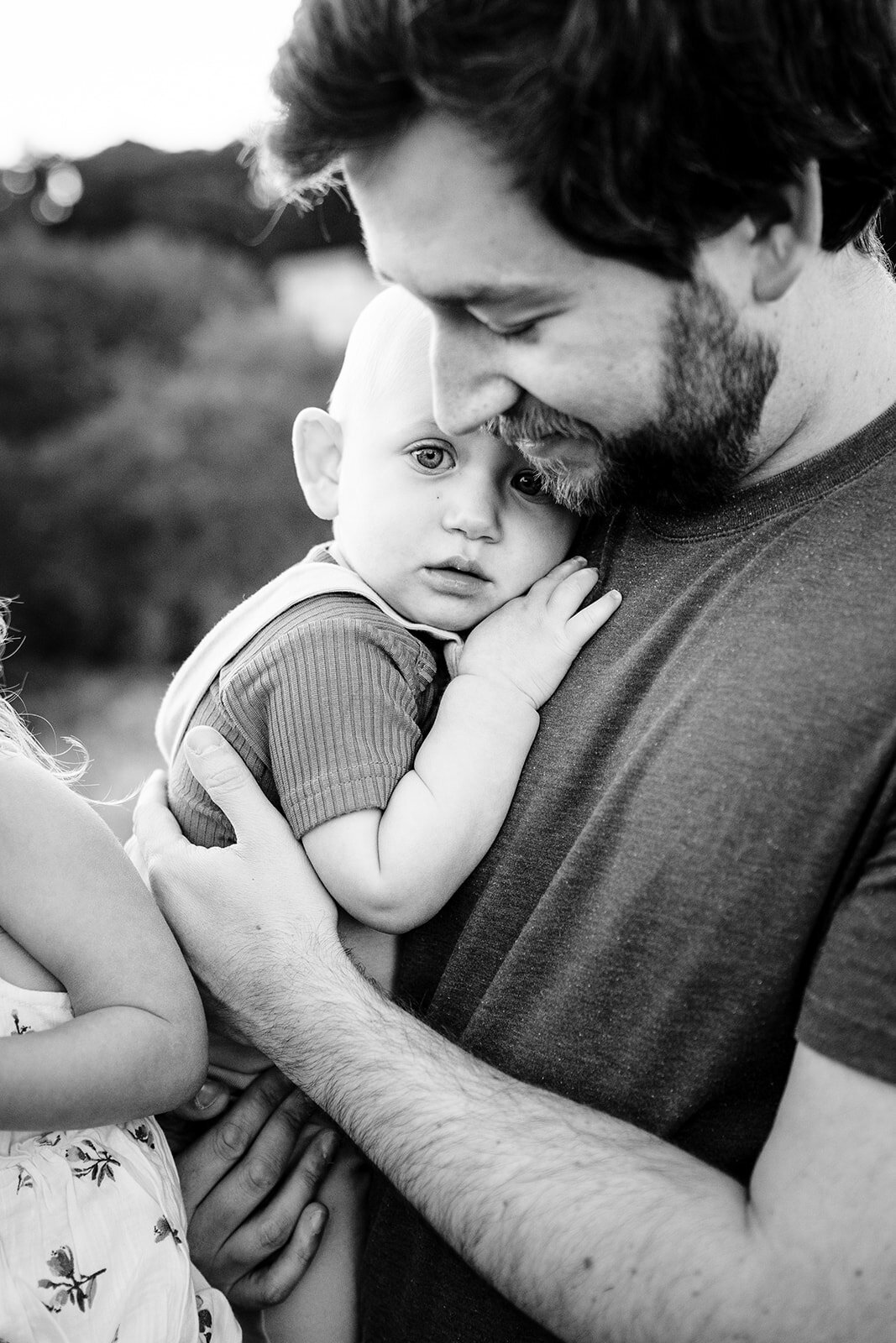 black and white portrait of a dad snuggling baby boy