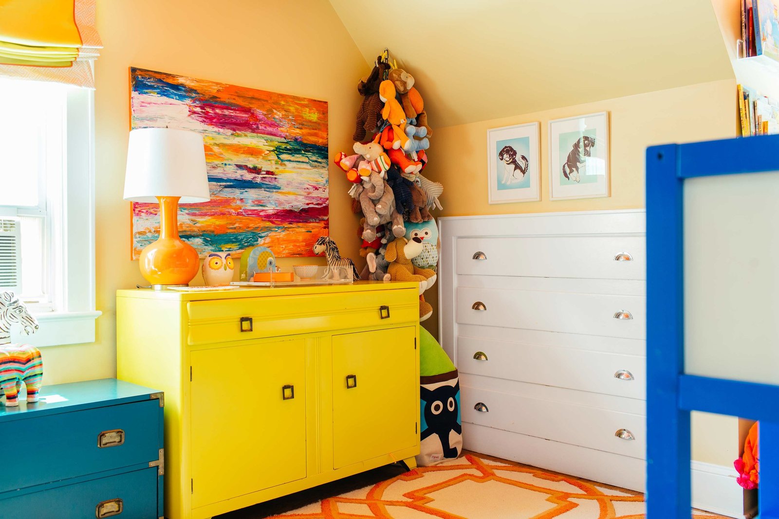 A boys bedroom with a yellow dresser and built in white dresser.