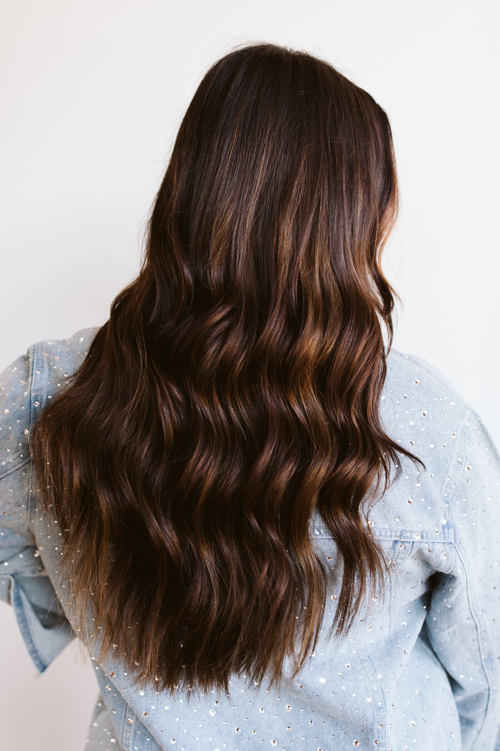 Long, wavy dark brunette hair flowing, exemplifying healthy and styled hair