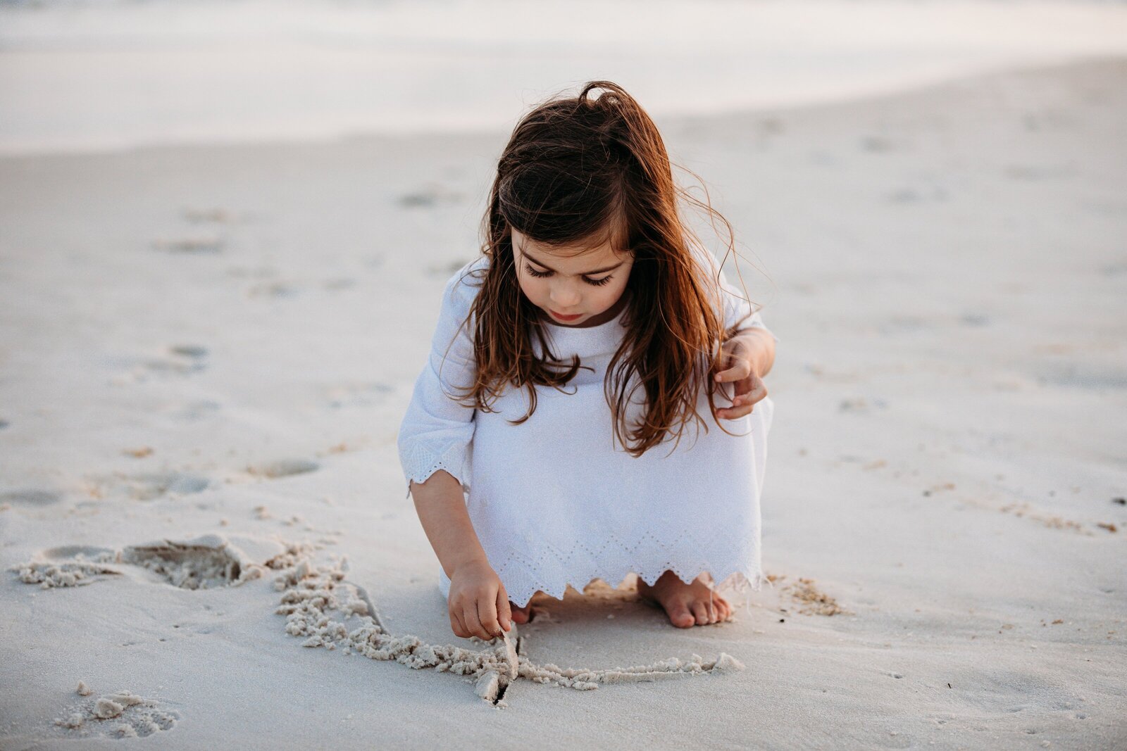 Pensacola  Family Photography session with daughter playing in the sand  on  Pensacola Beach, Florida