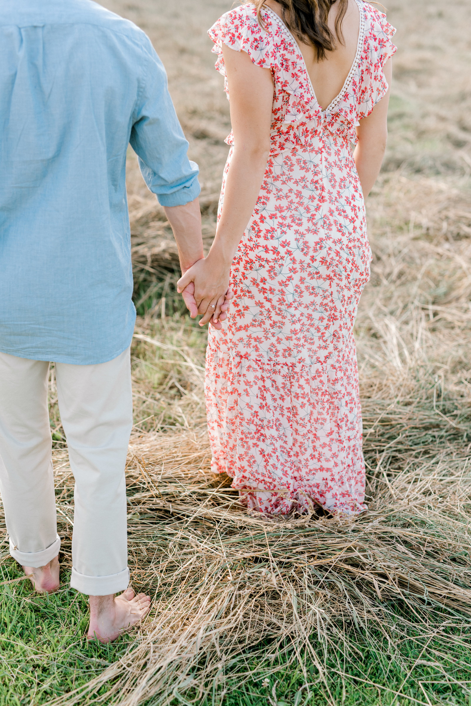 Erie Engagement Photographer- couple walking through a field