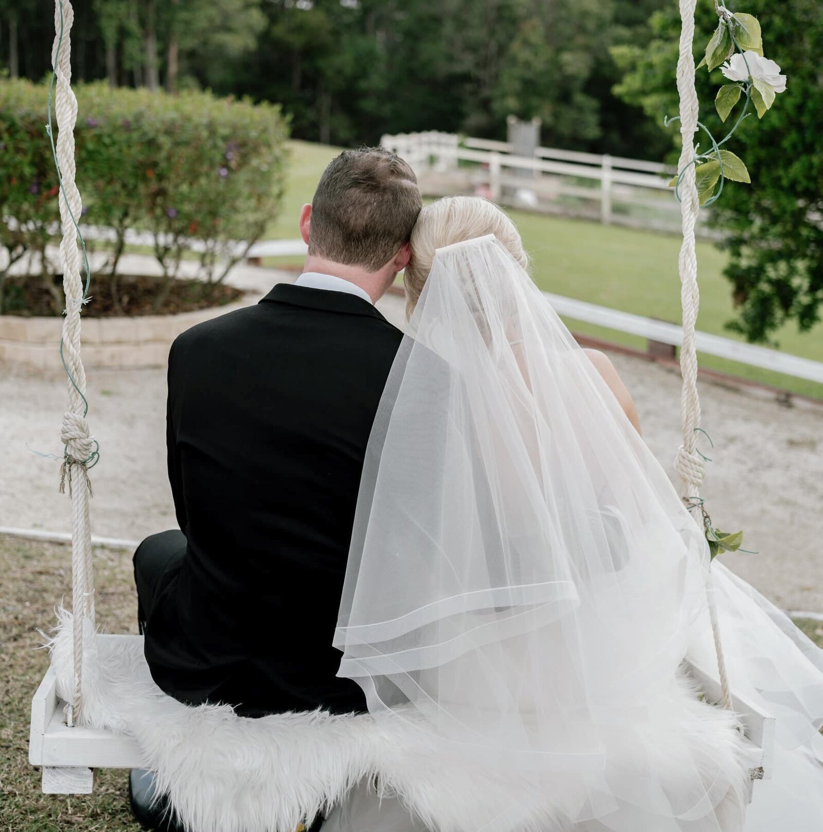 Bride and groom sitting on a swing at Austinvilla Estate