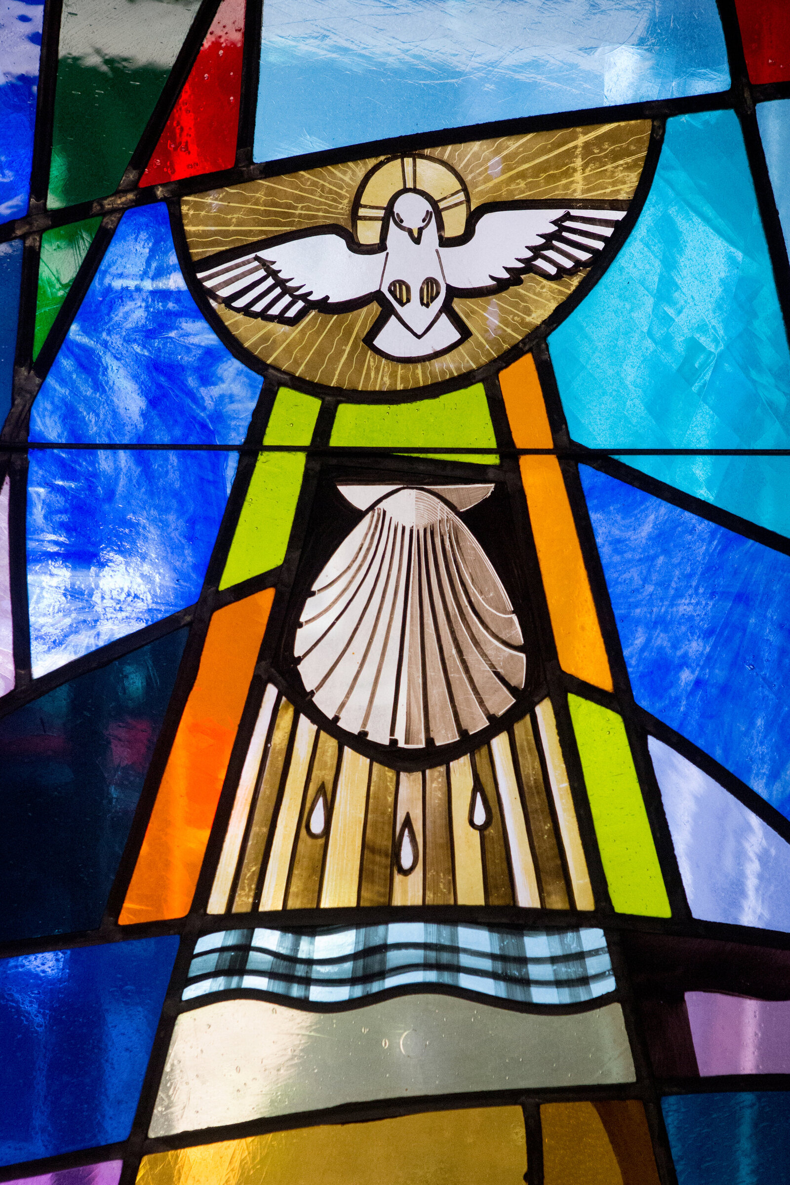 Detail of stained glass window showing dove and shell Saint Augustine New City Rockland County baptism photographer Milestone Images