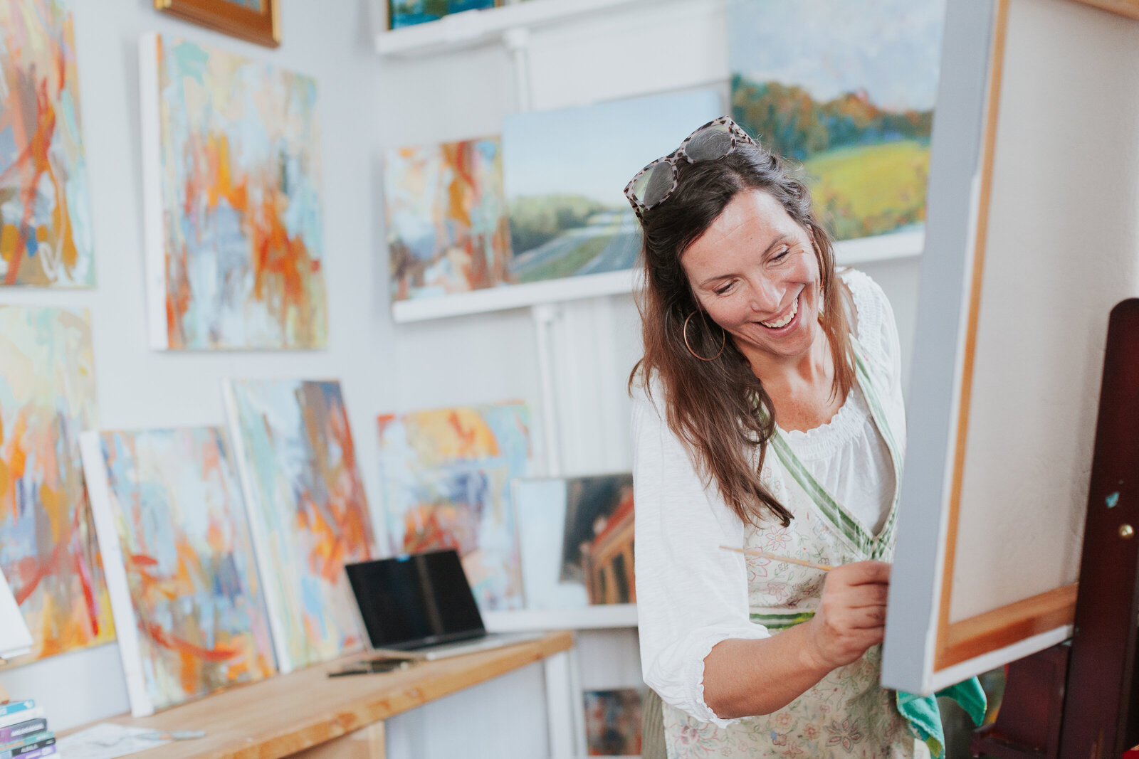 female-artist-smiling-while-painting-in-studio-for-studioworks-brand-session-east-blvd-dilworth-charlotte