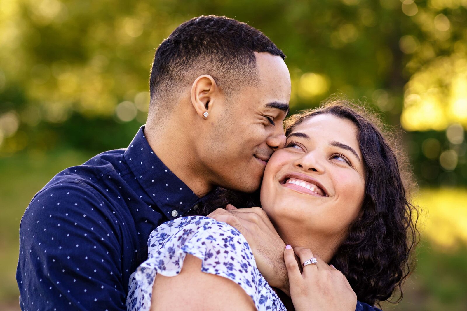 couple embraces during their engagement photos at the North Carolina Museum of Art