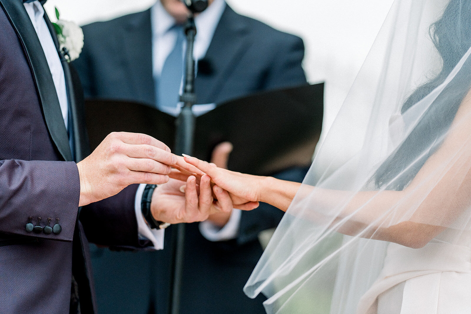 Groom places wedding ring on bride’s hand during elegant Hummingbird Nest Ranch ceremony, captured by a Los Angeles film wedding photographer in editorial style.