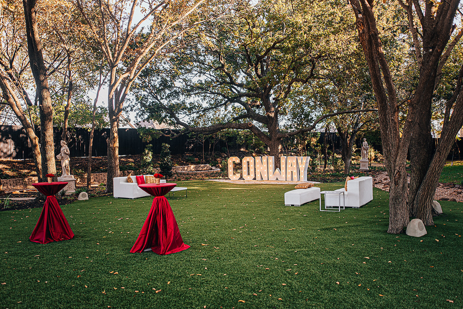 Outdoor garden wedding reception with tall trees and tables
