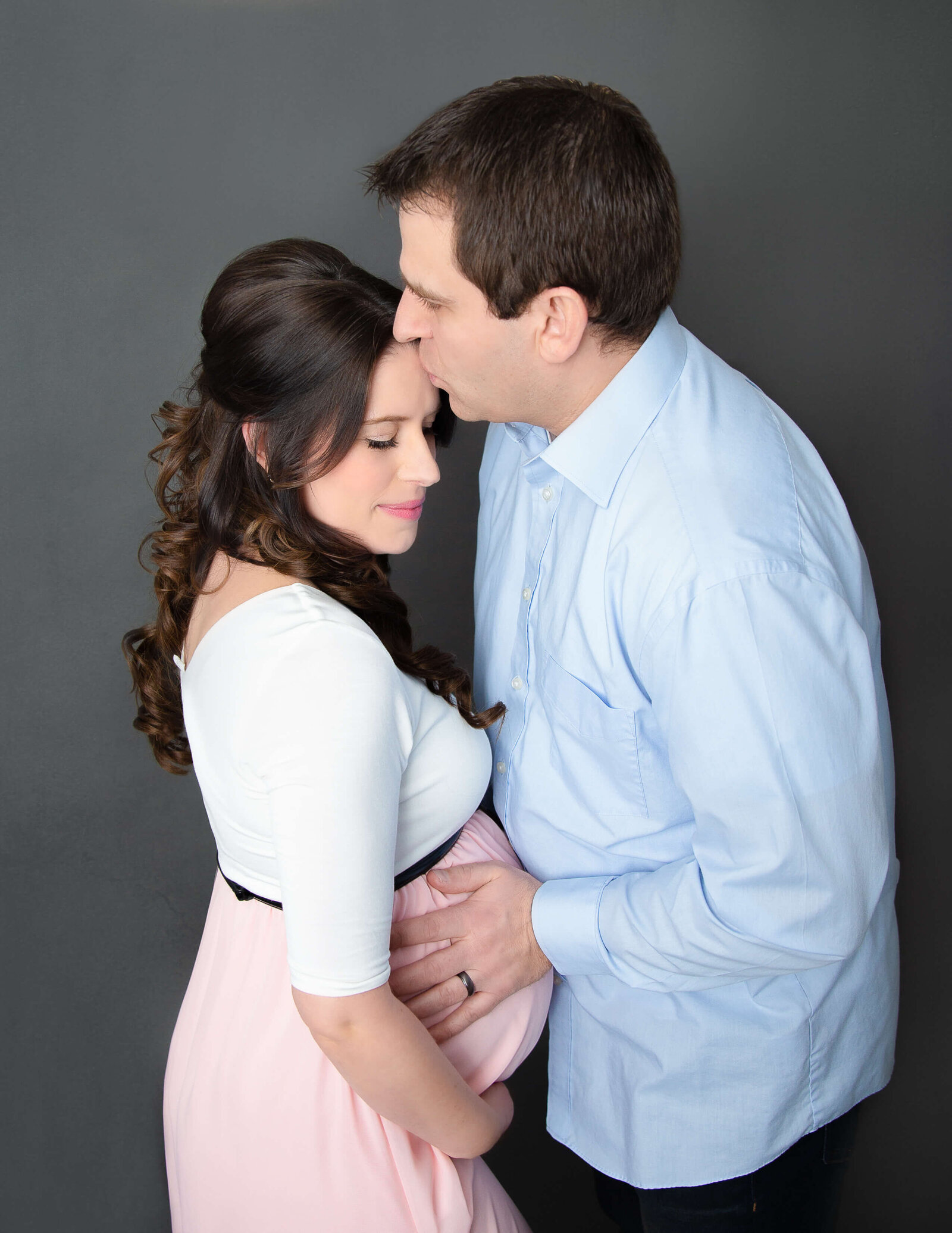 Sweet maternity couple posed in our Rochester, NY studio.