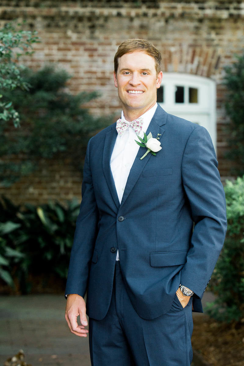Groom stands in front of the Rice Mill Building, Charleston, South Carolina. Kate Timbers Photography.