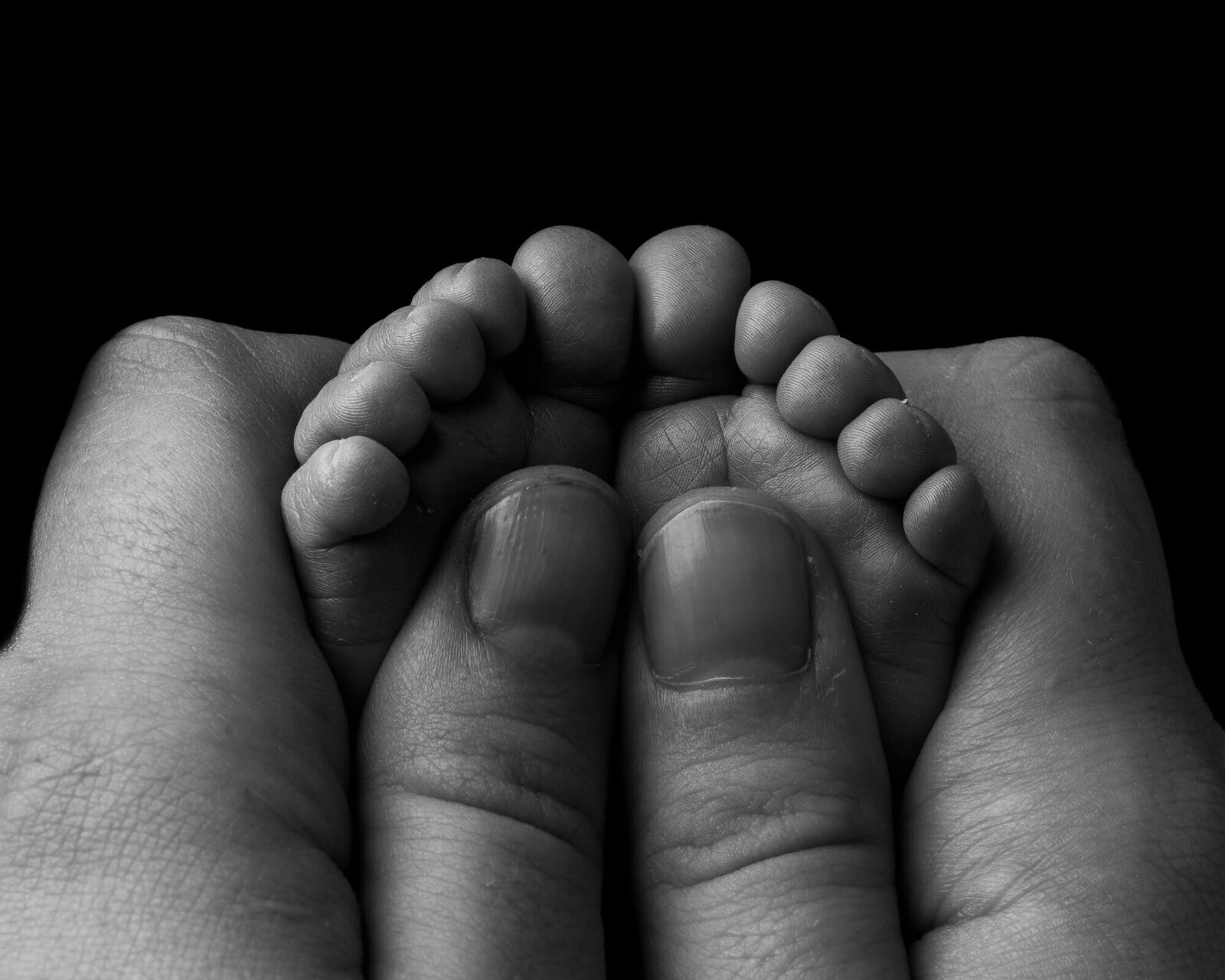 Black and white close-up picture of mom holding baby's feet