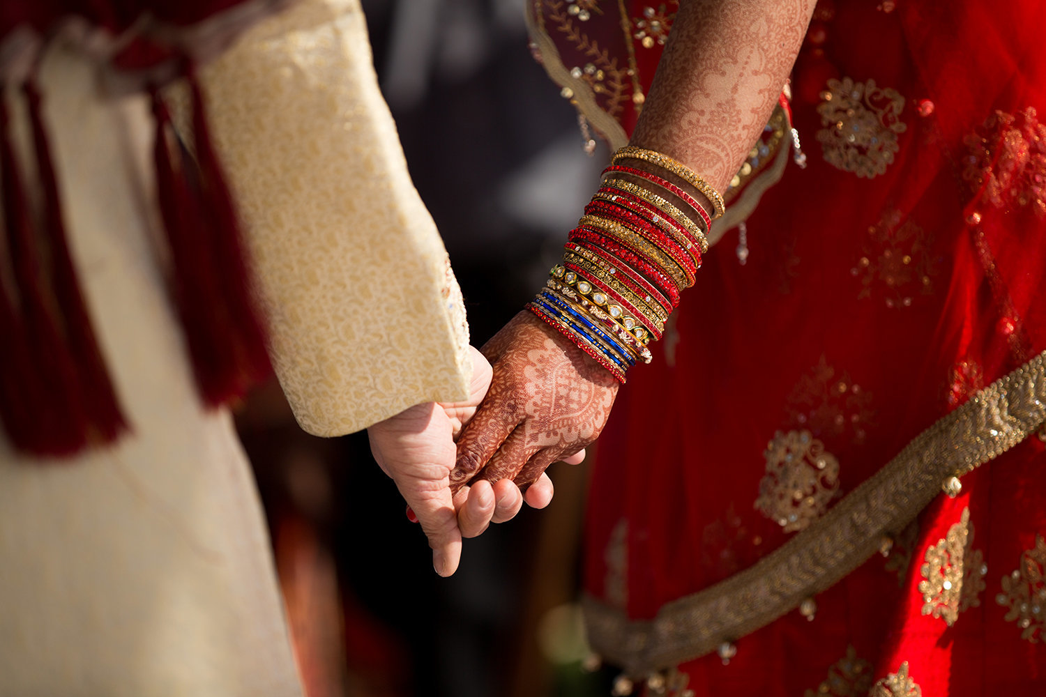 Close up of a bride and groom's hands during a Hindu wedding ceremony