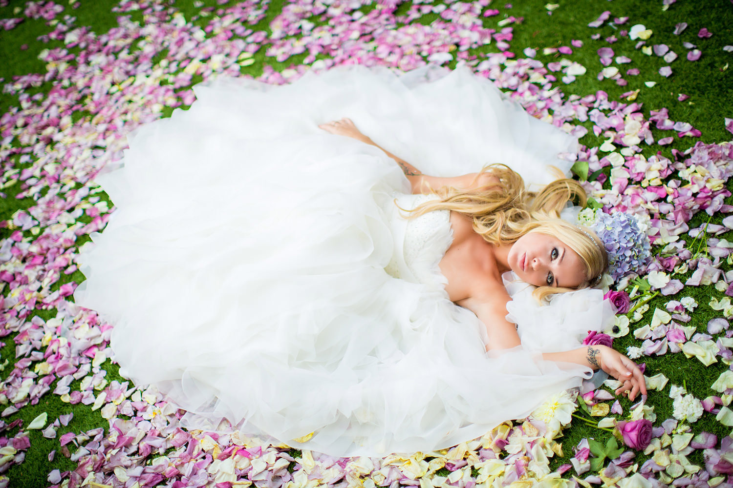 Amazing bridal portrait of bride laying on a bed of rose petals