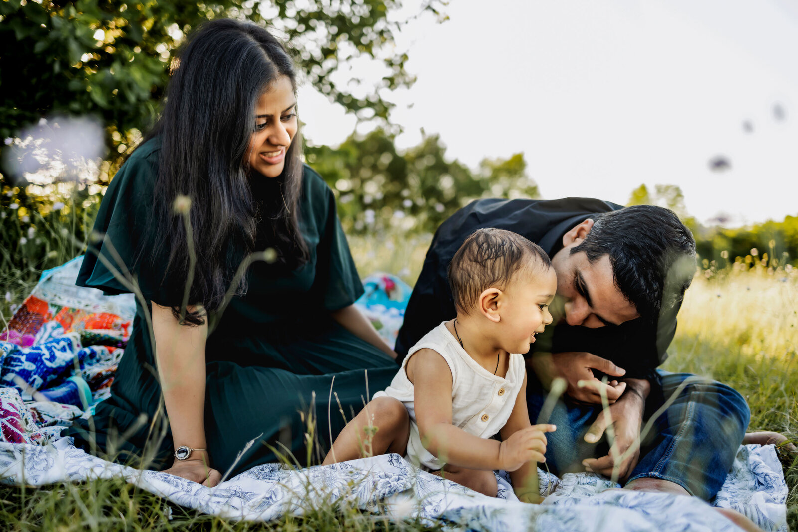 Indian family play with infant son in the park in plano texas