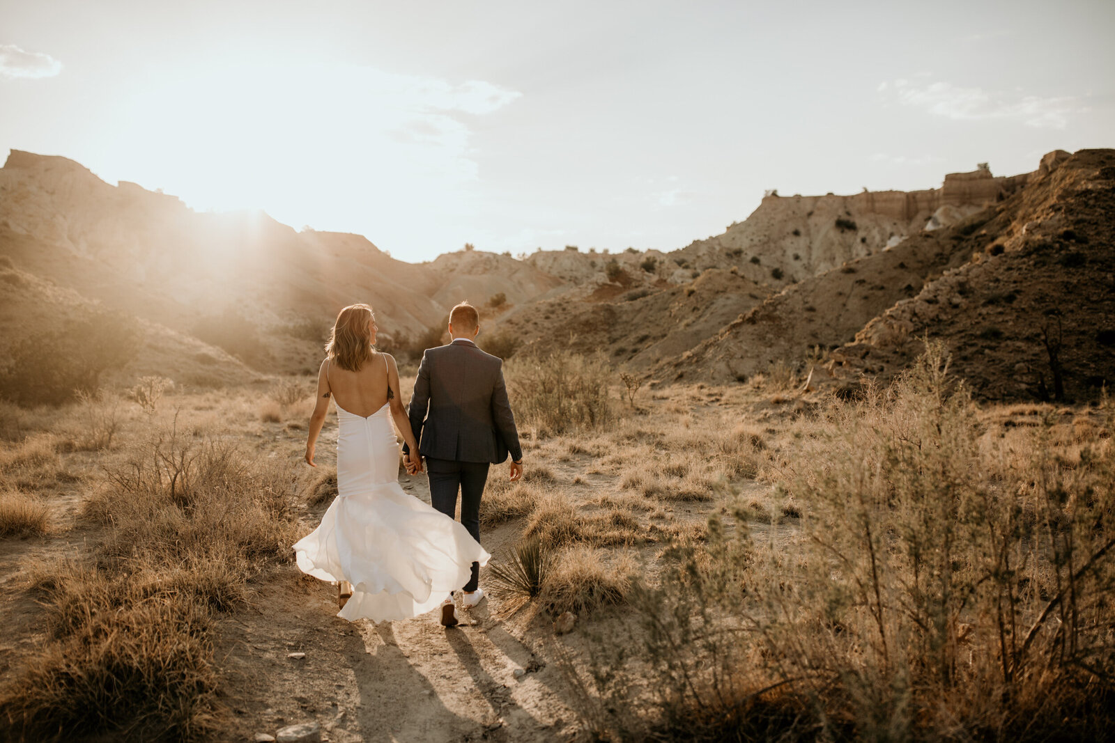 bride and groom walking in the new mexico desert together
