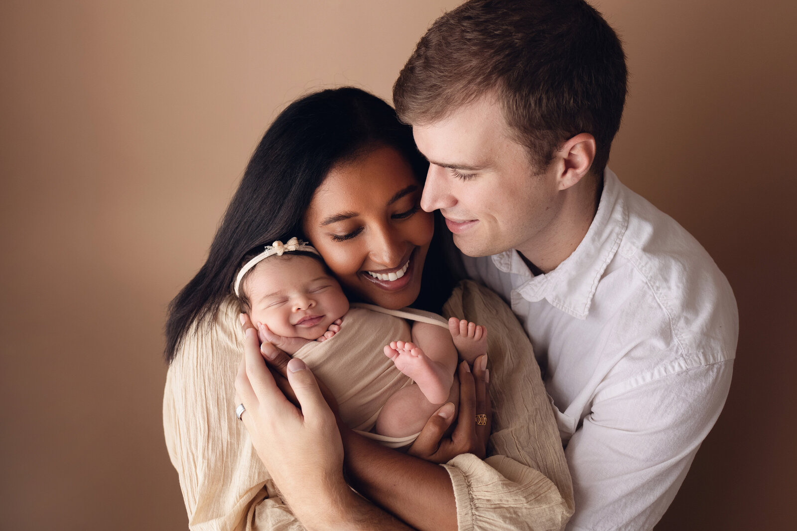 family with newborn baby smiling