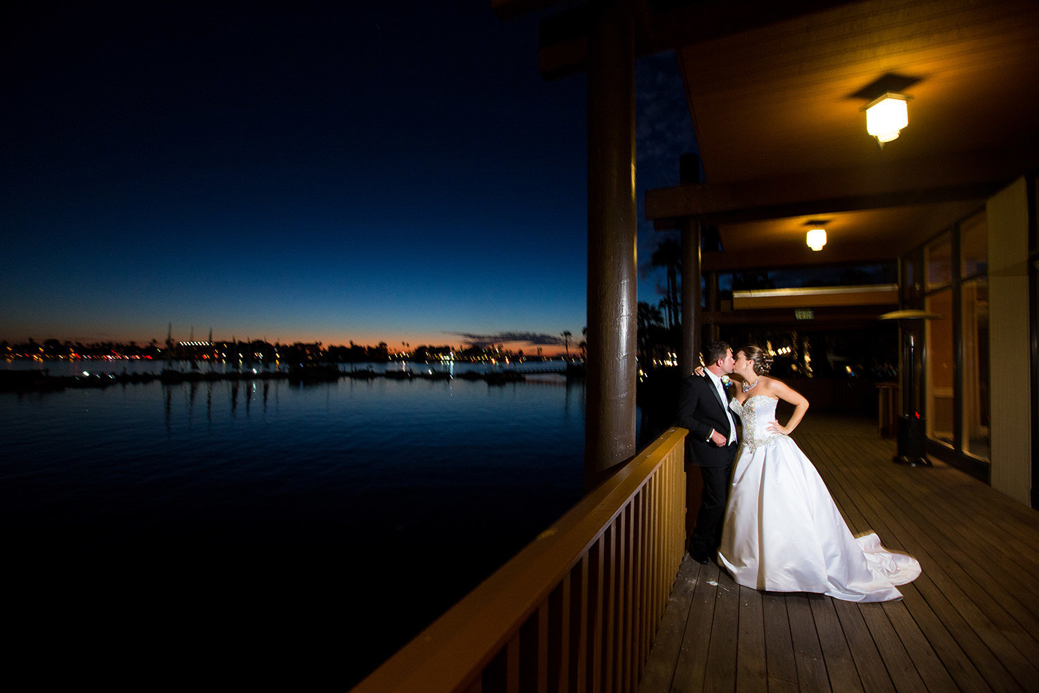 bride and groom on dock at sunset