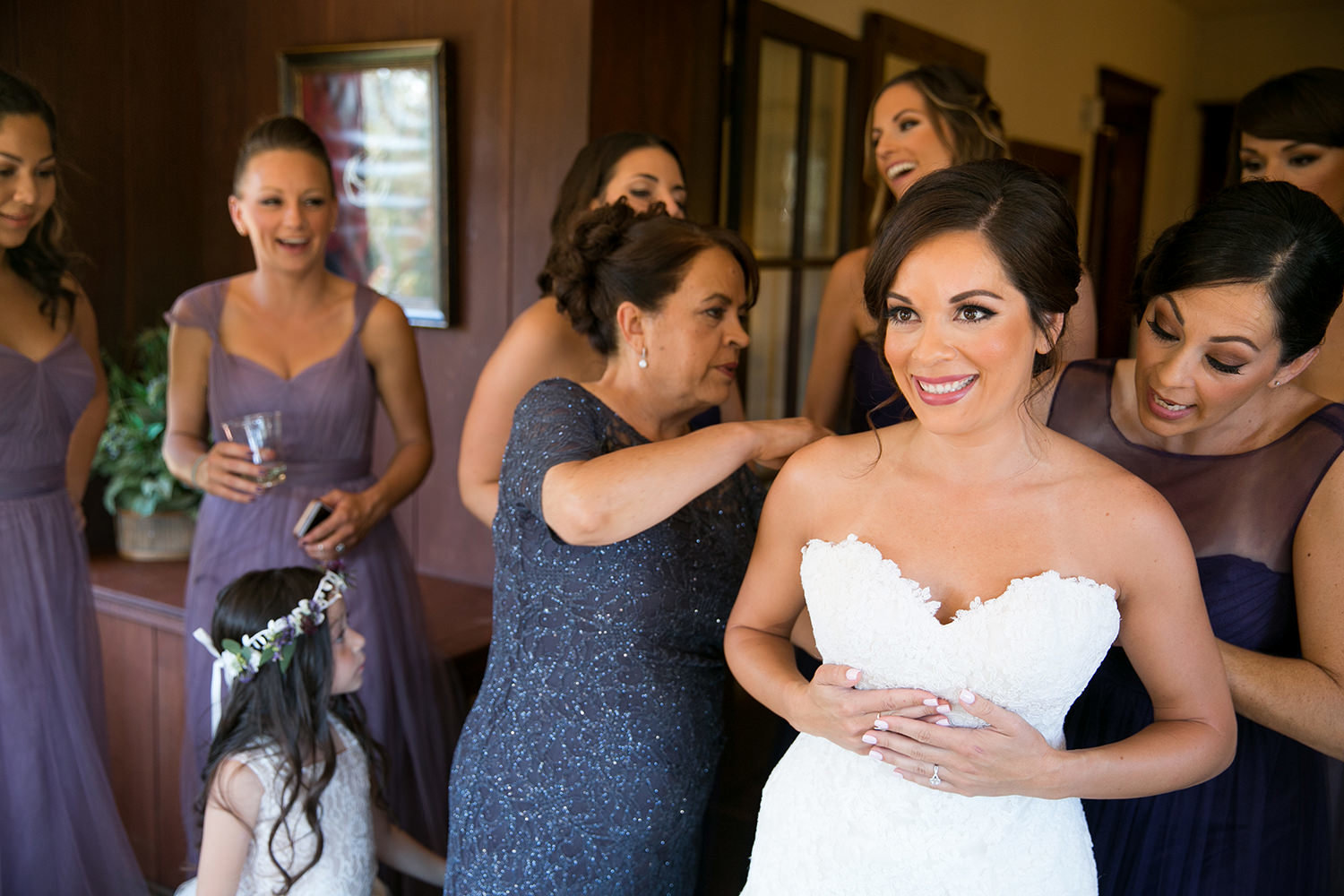 bride putting dress on with friends