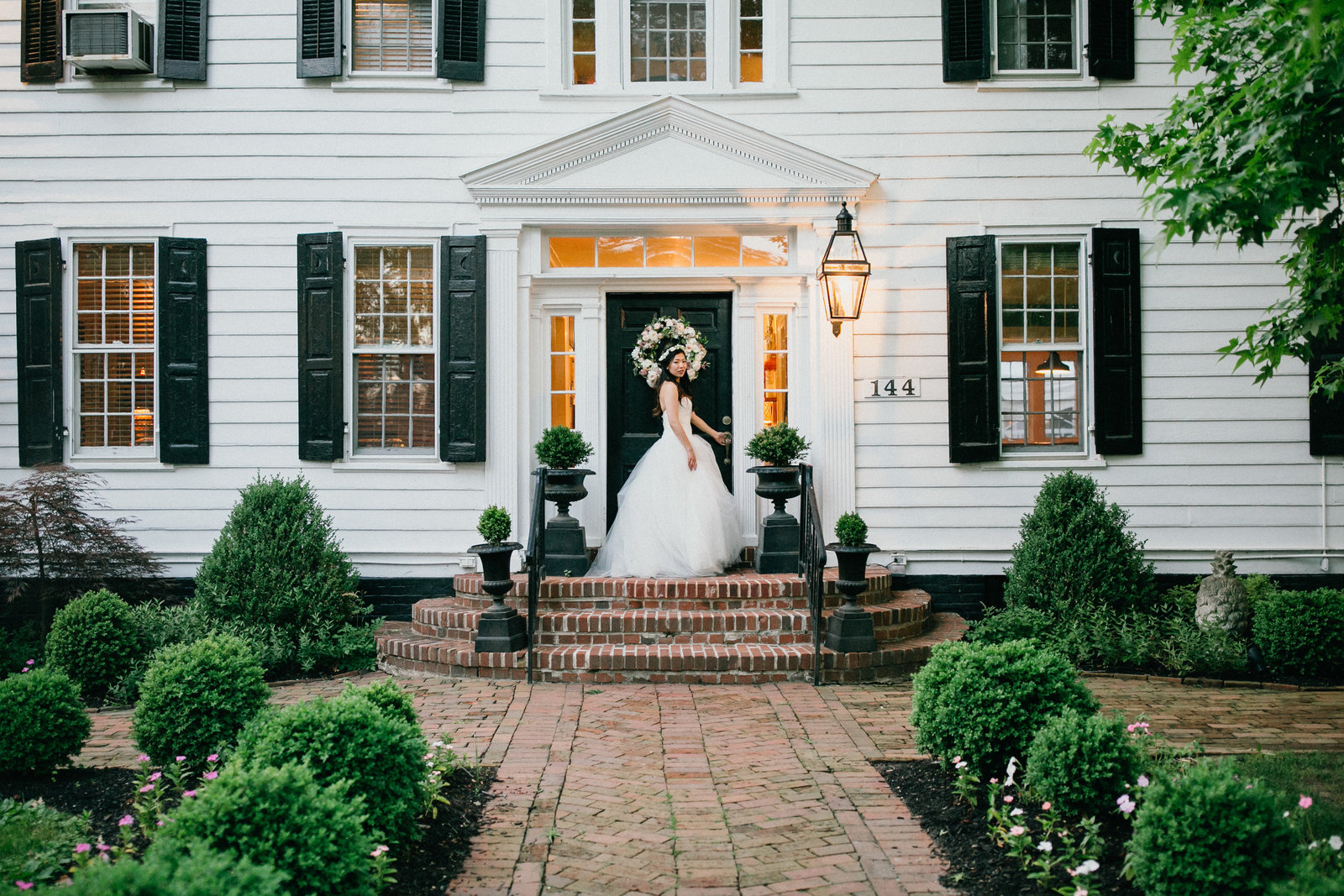 Bride showing off her gorgeous gown, in front of the historic Inn at Fernbrook Farm.