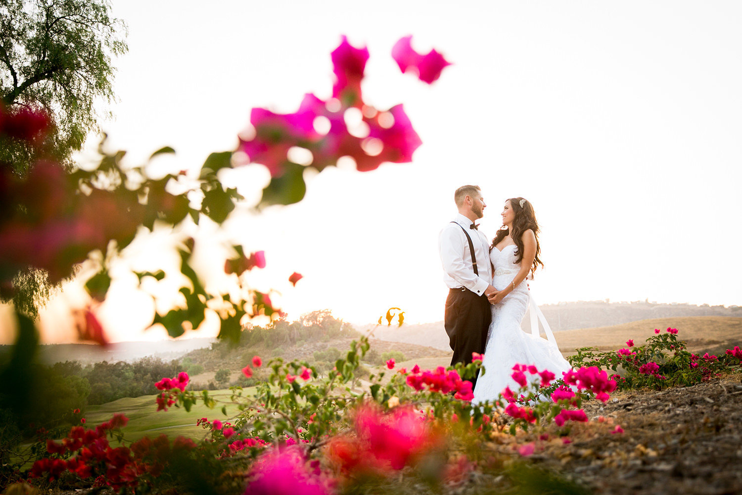 bride and groom at sunset with flowers
