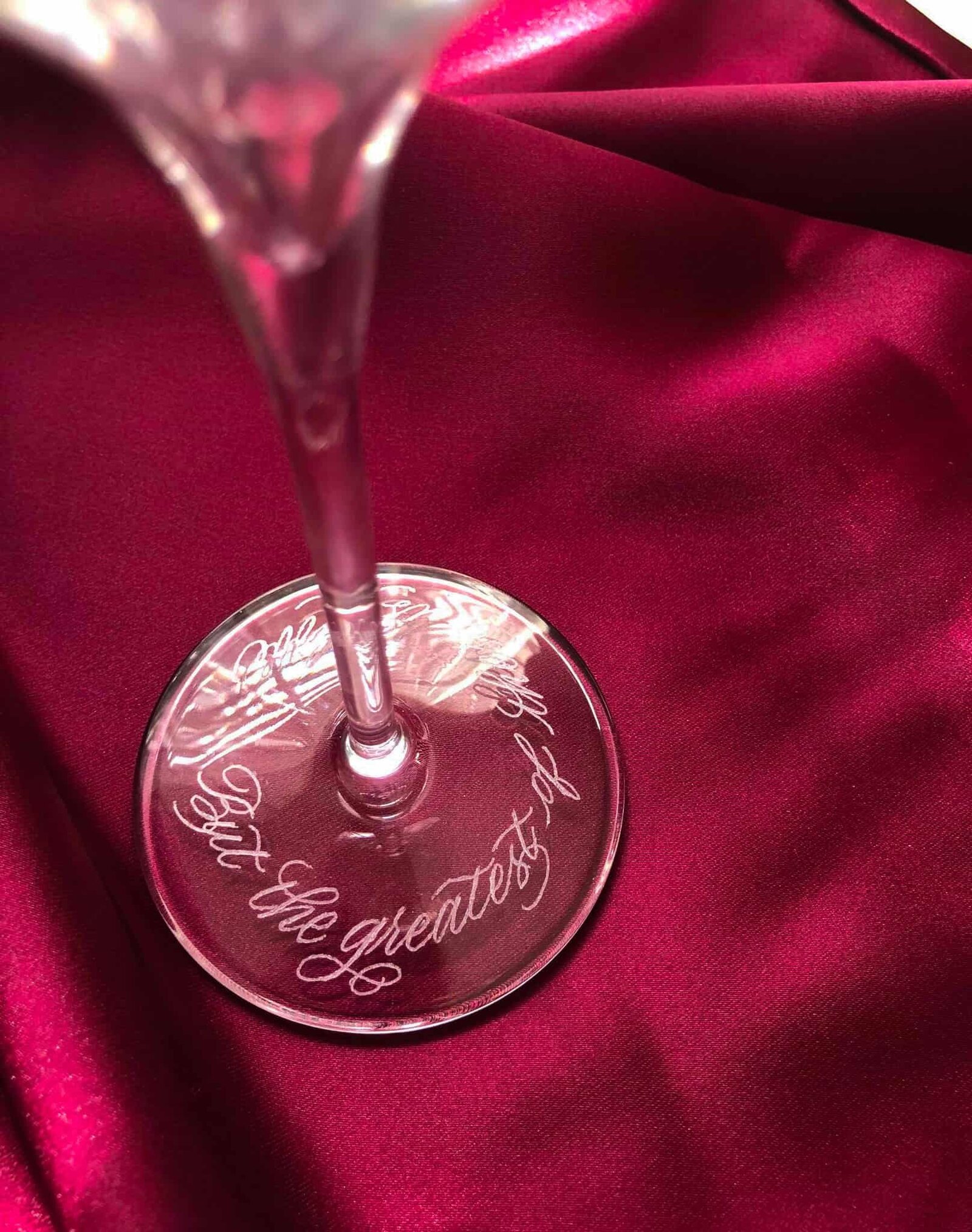 engraved champagne glass set against a red silk background