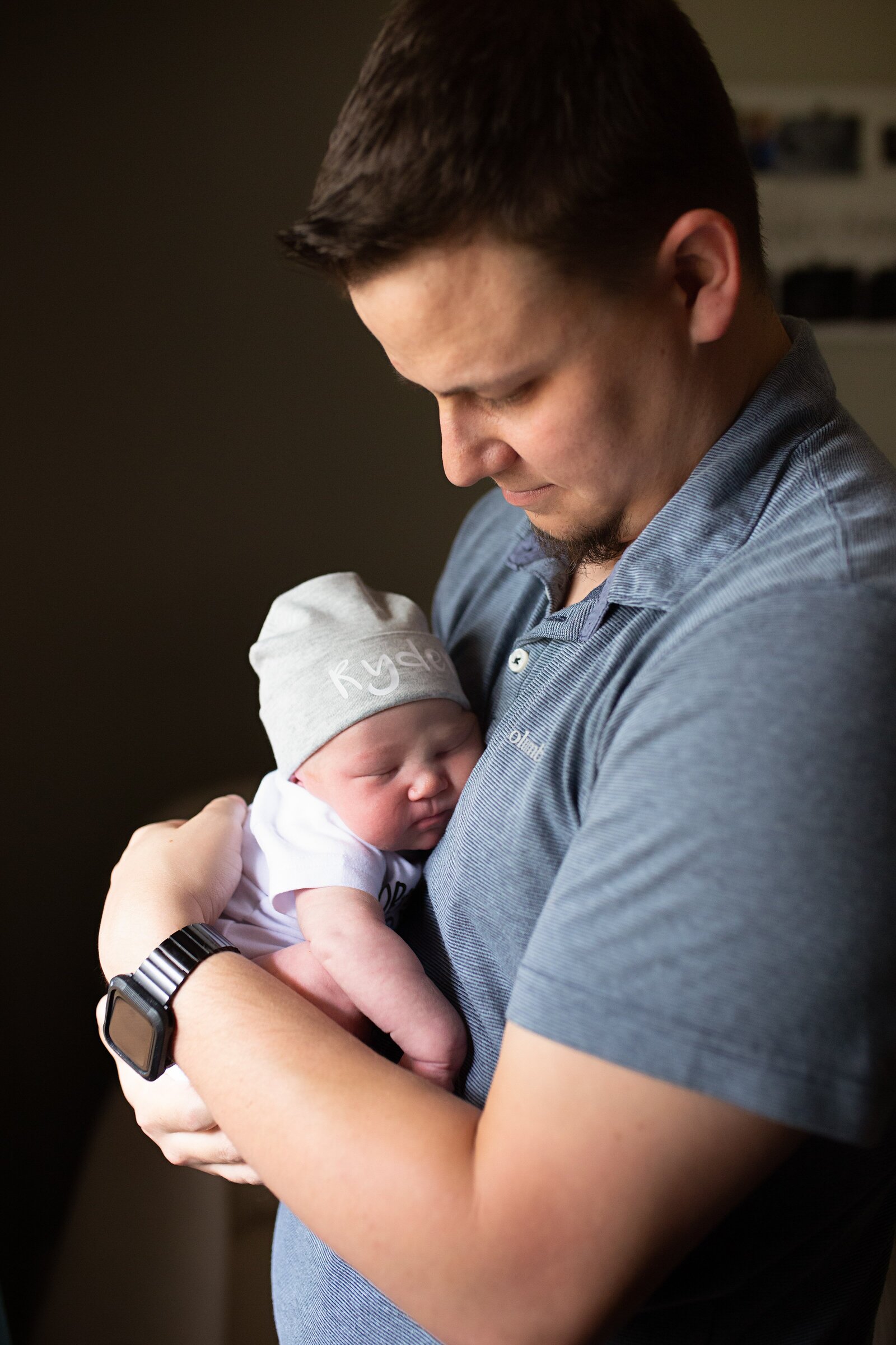Daddy holding and admiring newborn son during newborn photo session