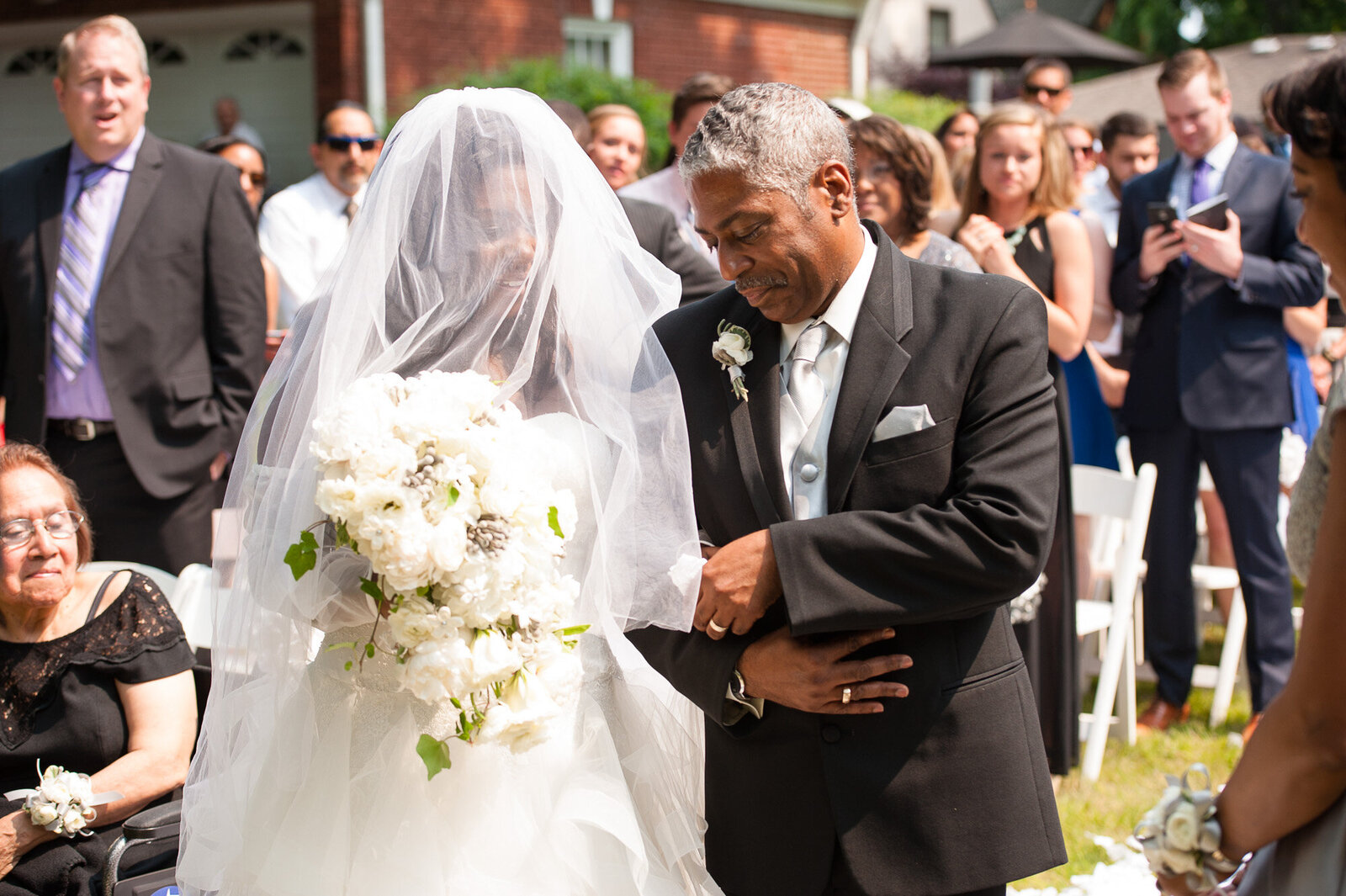 Bride with her father walking on the aisle with guests behind