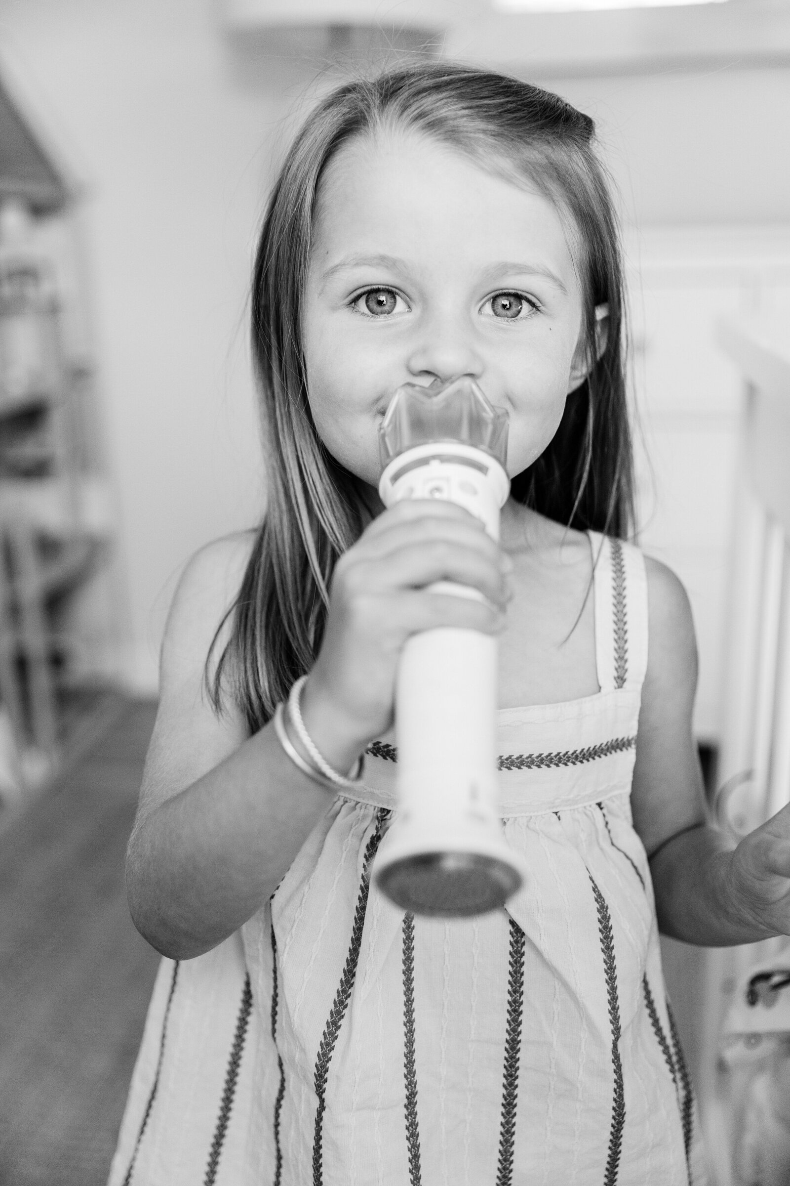A little girl playing with microphone during an in-home family session in Lexington KY.