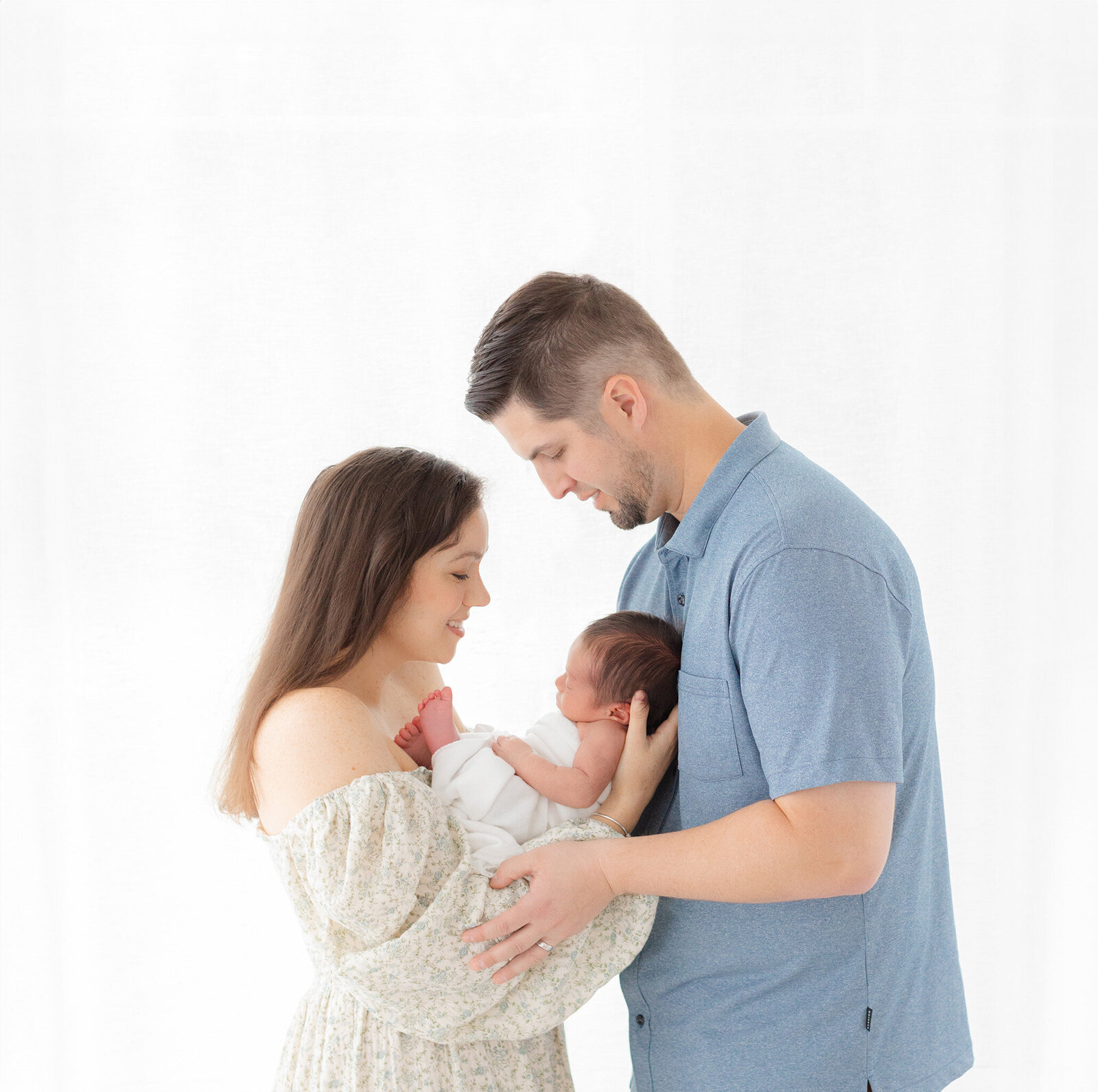 Parents holding baby at Massachusetts newborn photography session