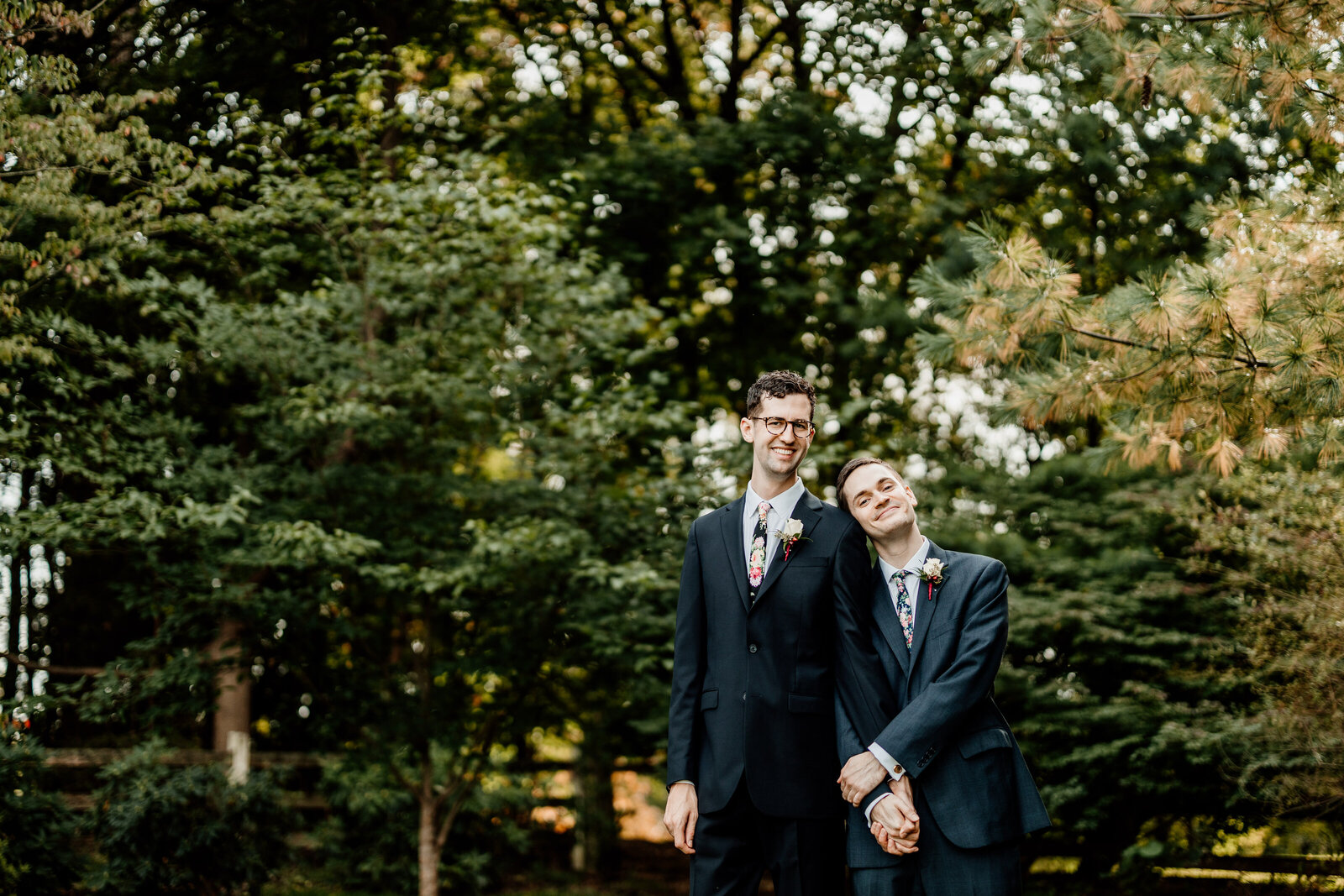 gay grooms holding hands in trees
