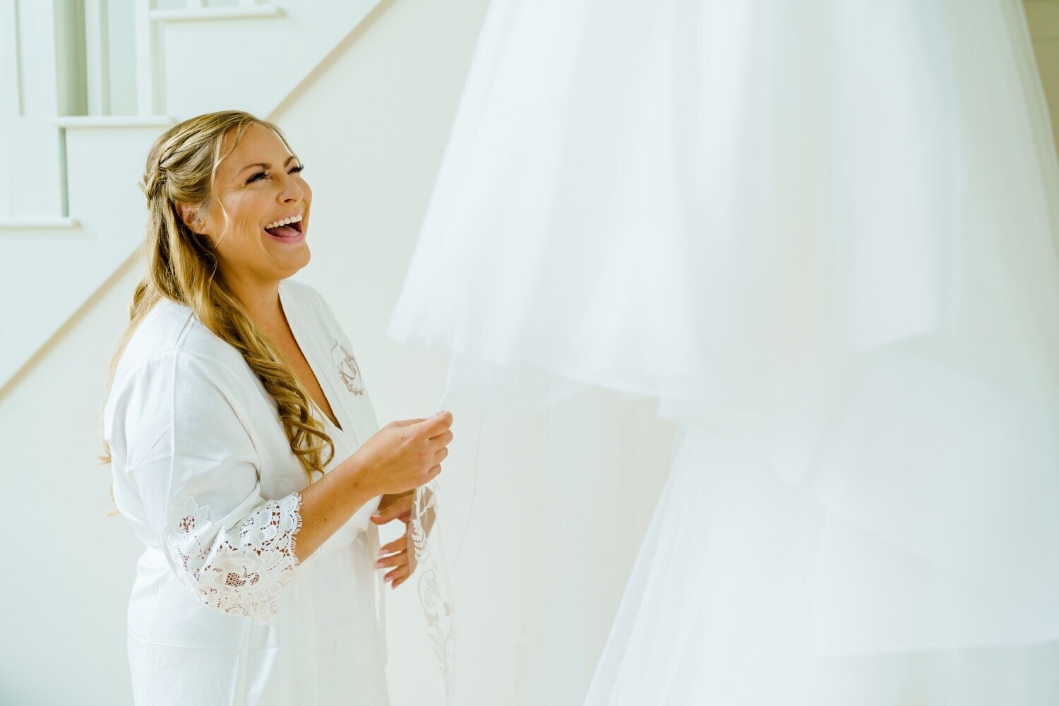 New Hampshire Bride laughing and smiling up at wedding dress