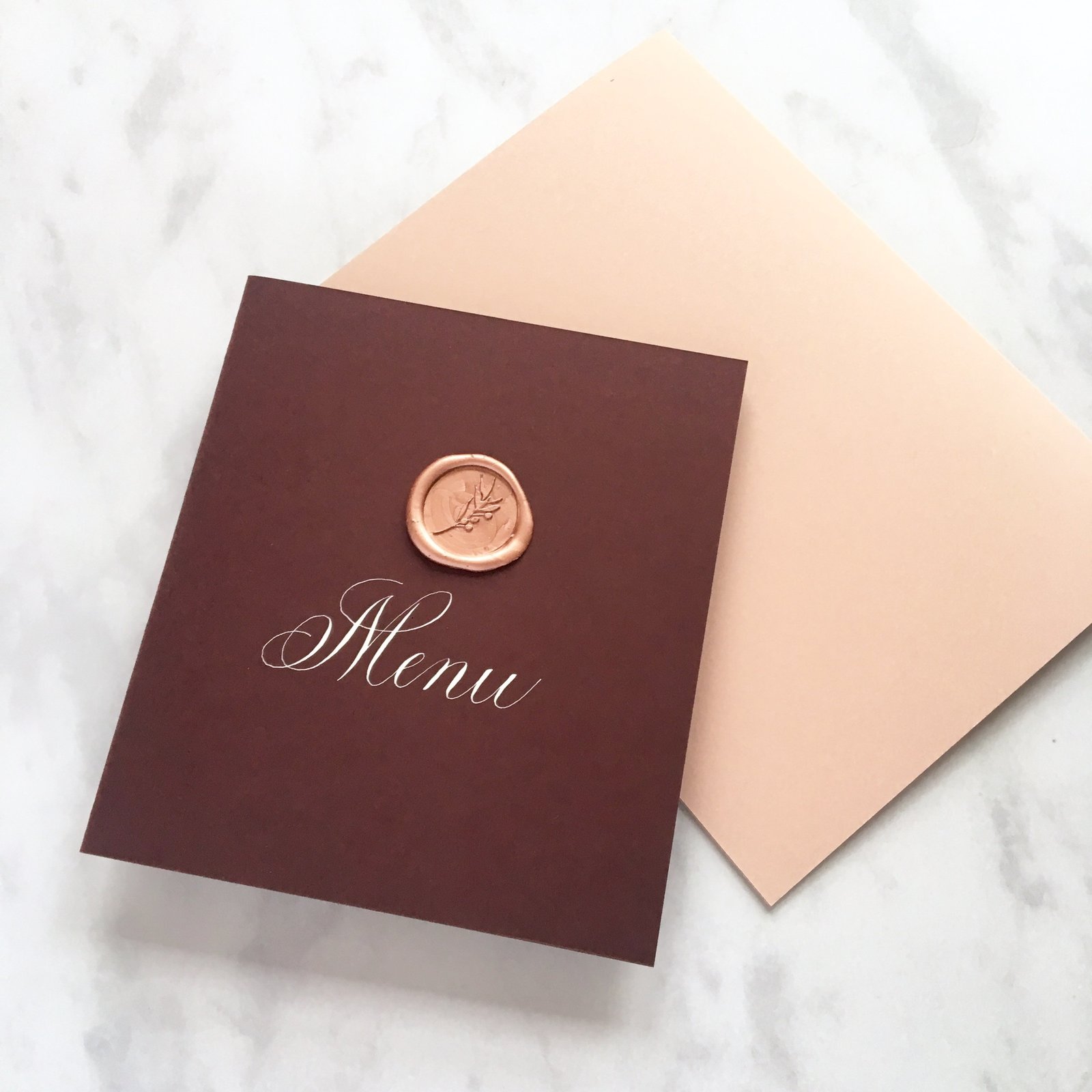 Menu booklets with white calligraphy and wax seal