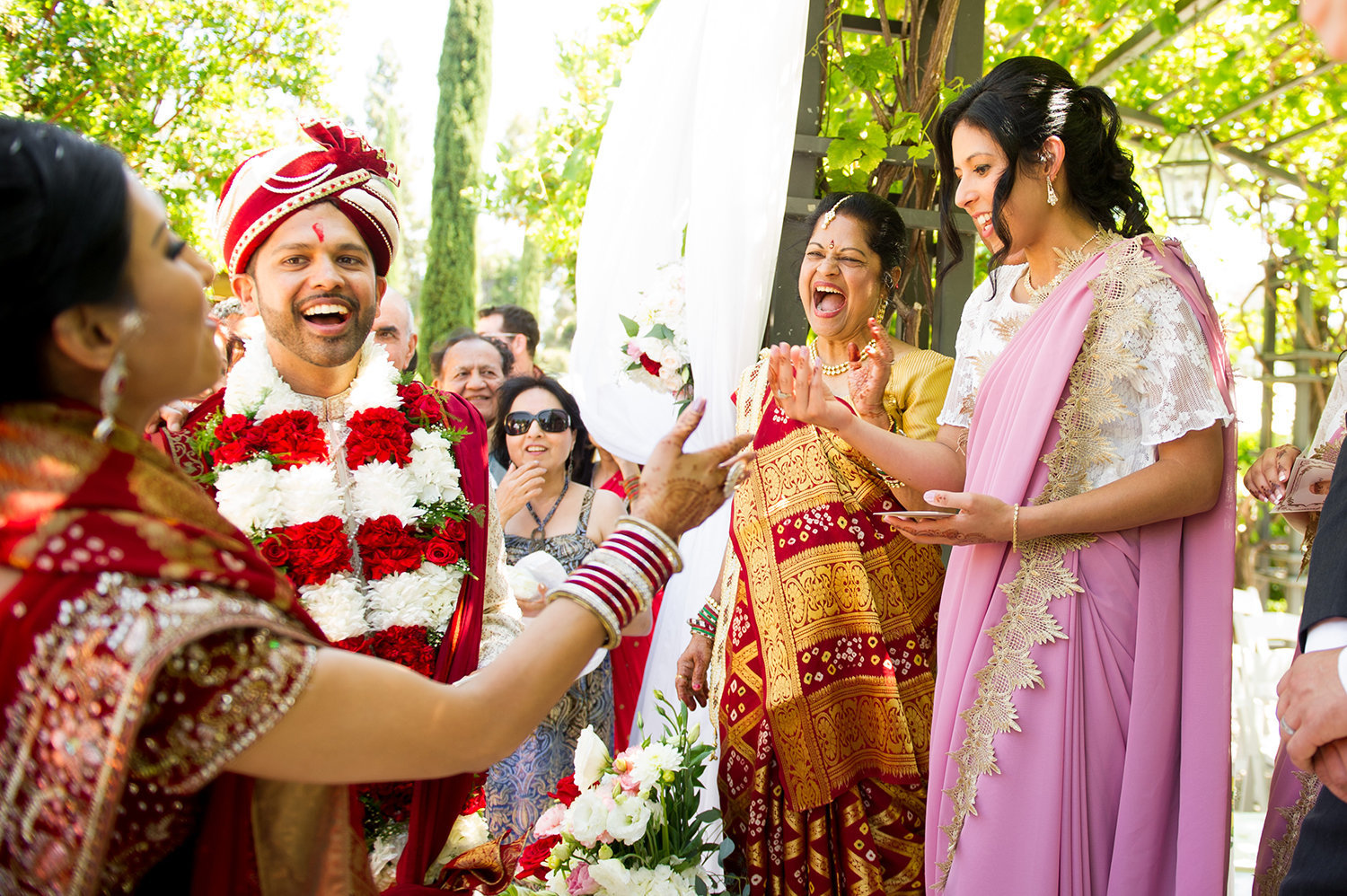 The groom bargains with bridesmaids to get his shoes back after a traditional hindu wedding ceremony