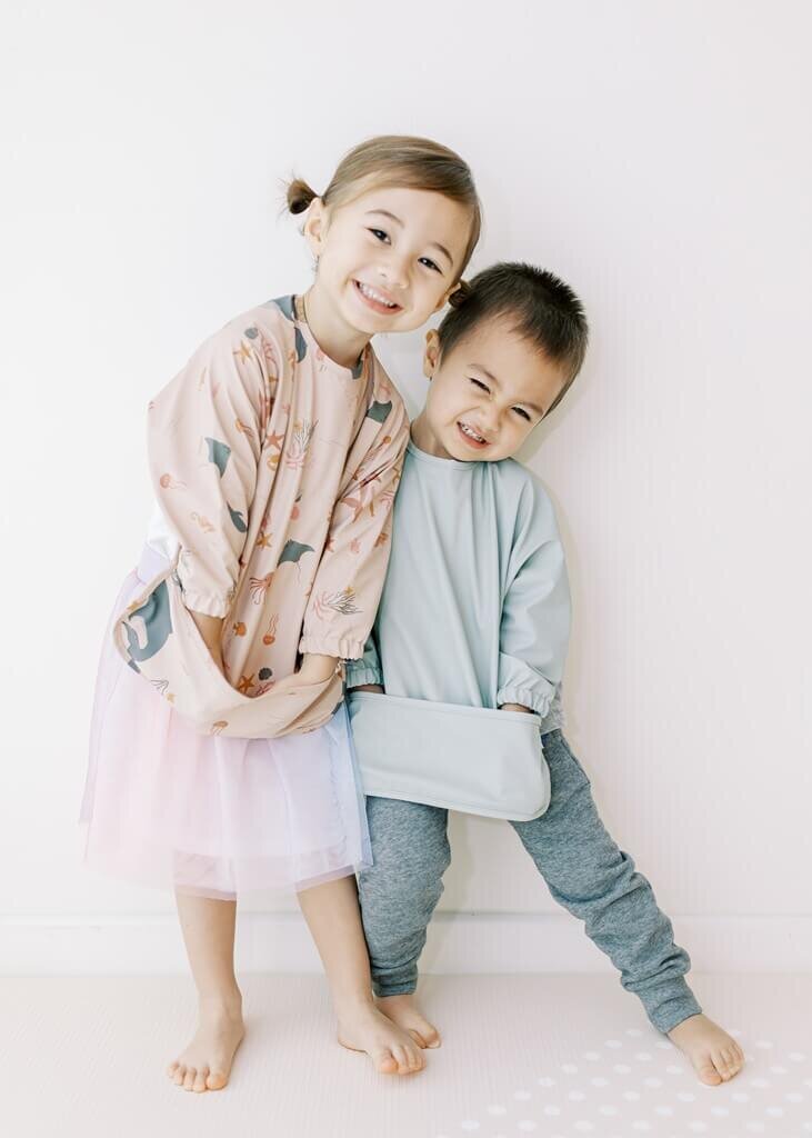Boy and girl smiling at the camera for a clothing brand photoshoot.