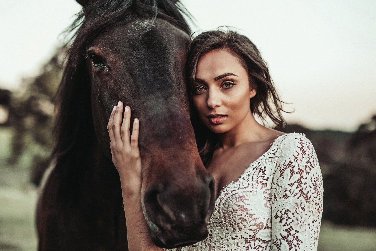 Bride posing with horse in wedding attire