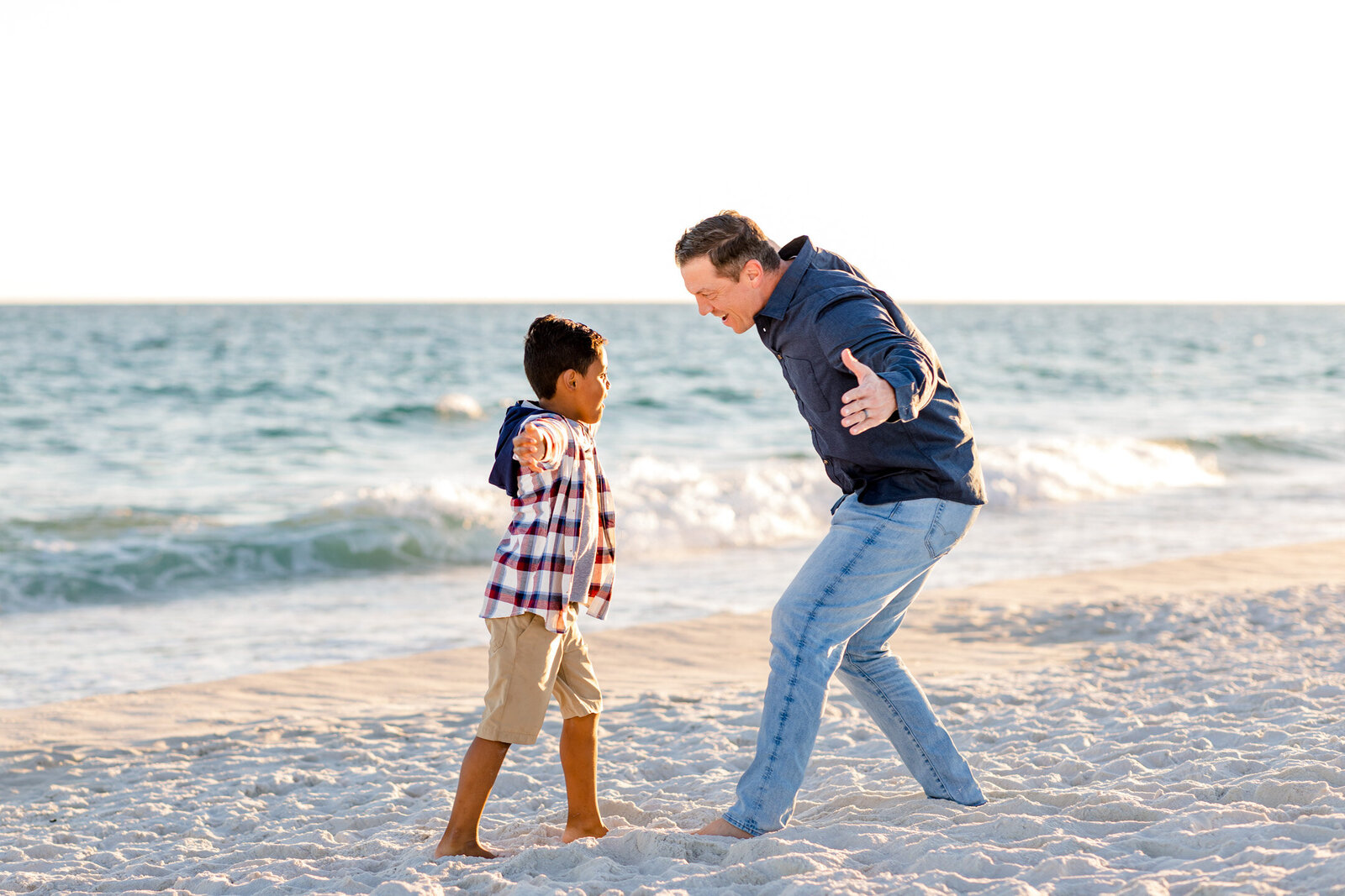 Father and son playing during family photo session on Pensacola Beach.