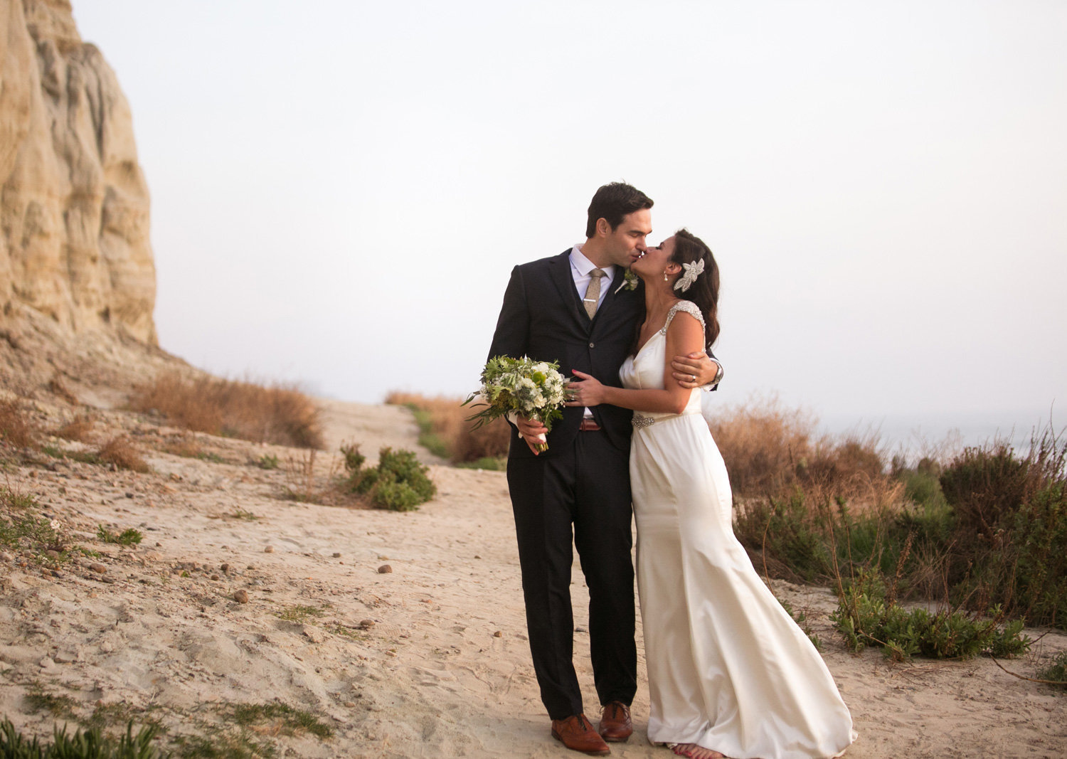 bride and groom walking on the beach in san clemente